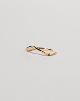 View from the side of the Gold Three Stone Blue Sapphire Low Peak Band on light color background.