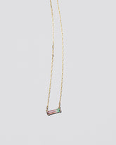 Kiss Me Necklace on light color background.