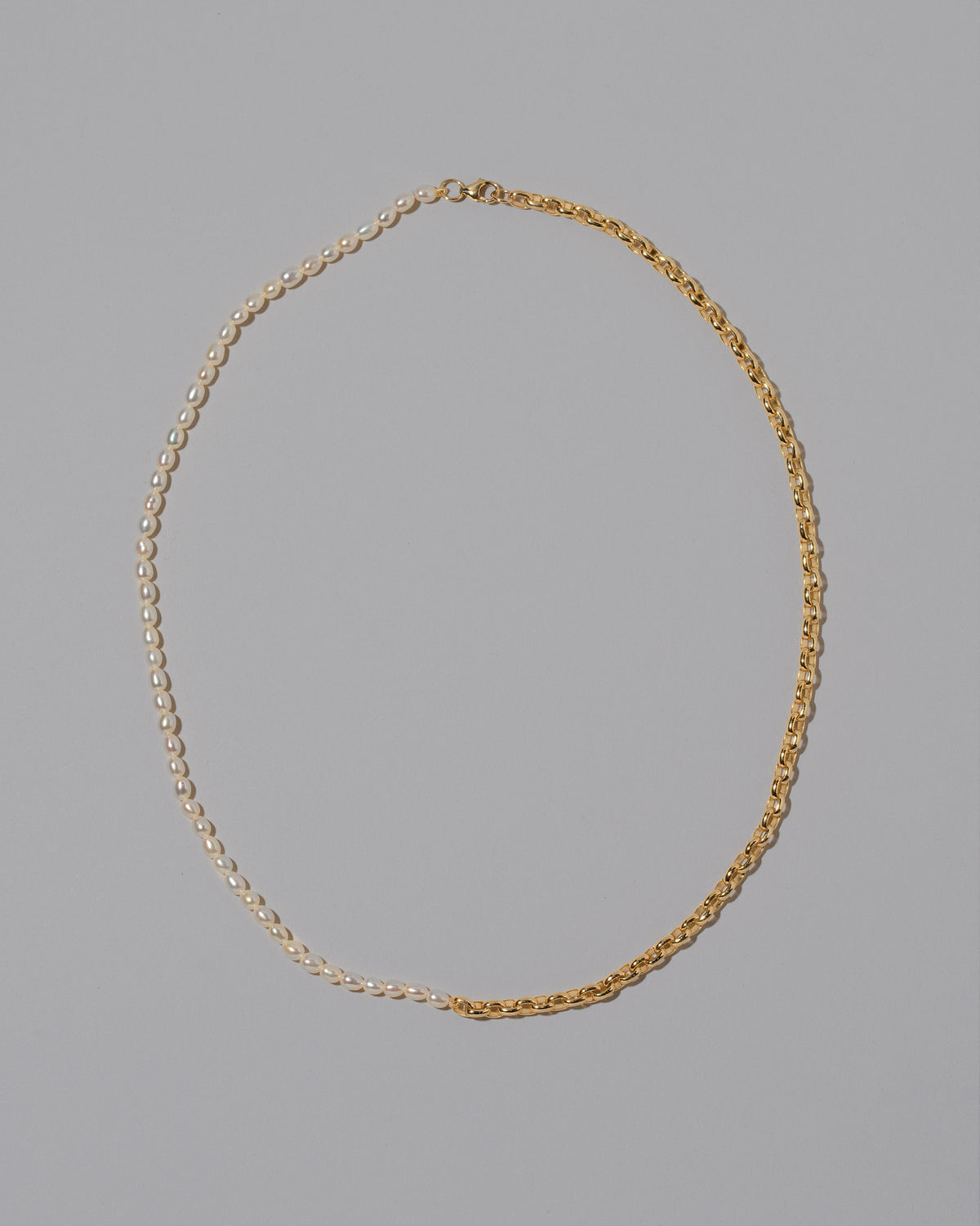Half Short Loop Chain & White Seed Pearl Necklace on light color background.