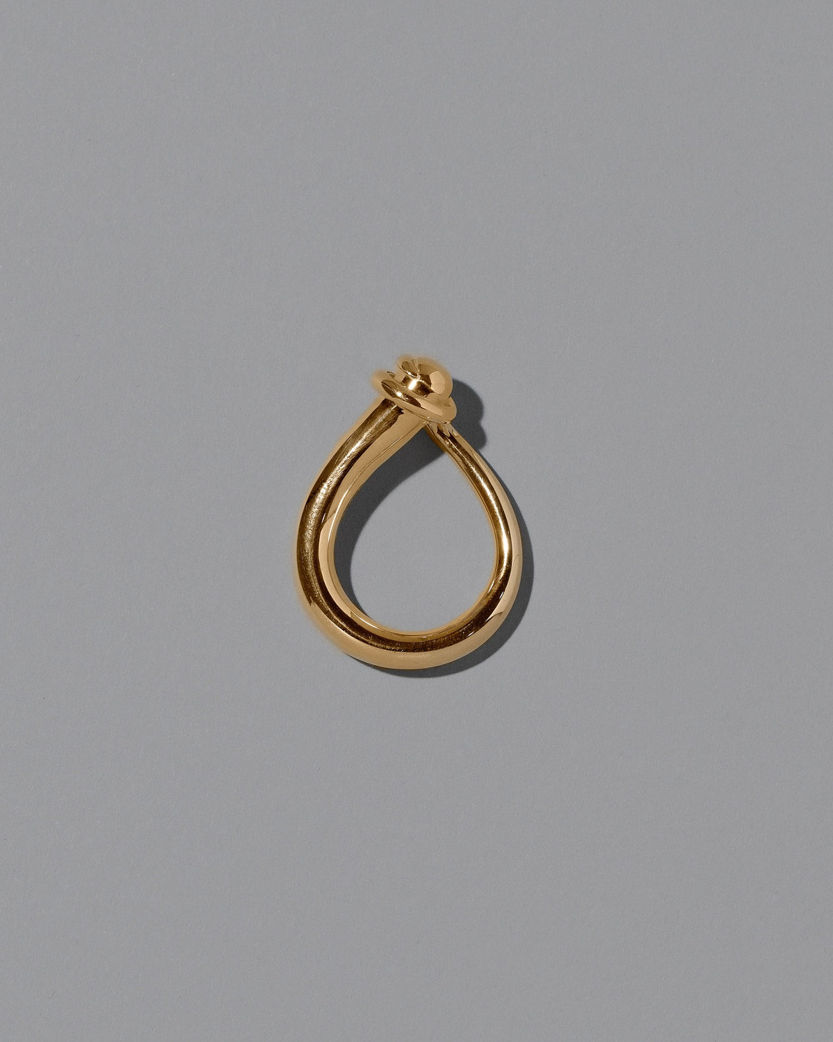 View from the side of the CRZM Gold Boulder Ring on light color background.