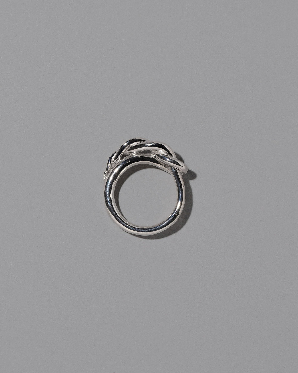 View from the side of the CRZM Sterling Silver Ophiolite Ring on light color background.