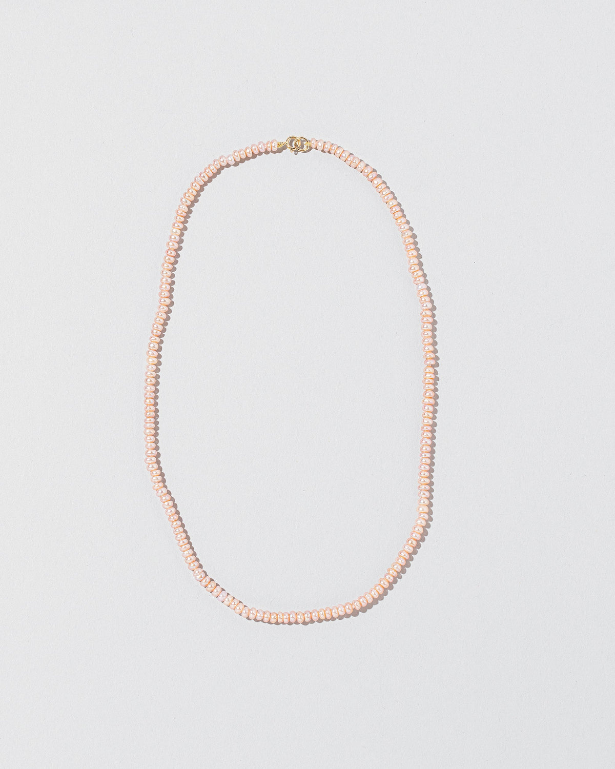 Pink Peony Pebble Seed Pearl Choker Necklace on light color background.