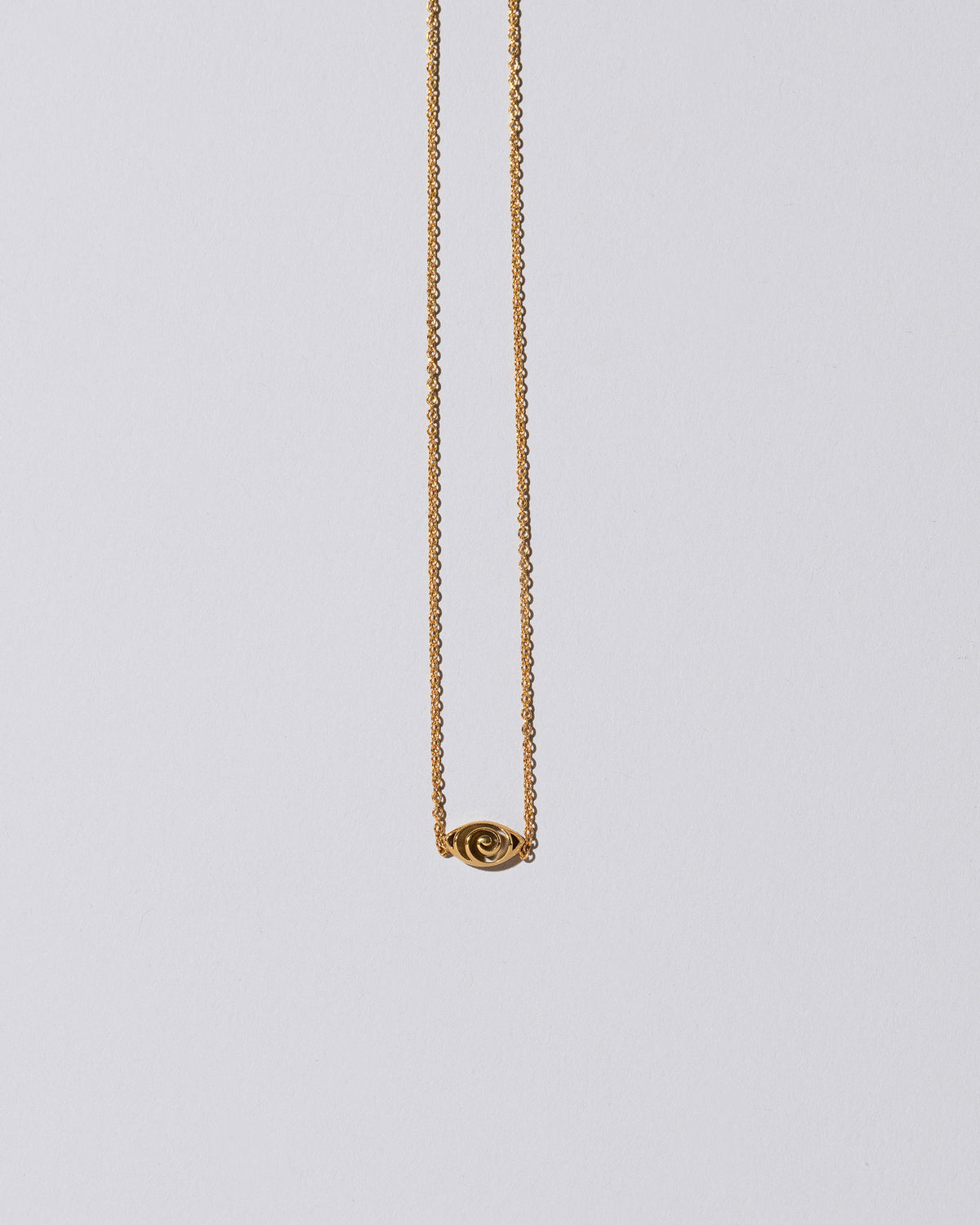 Gold Altered State Necklace on light color background.