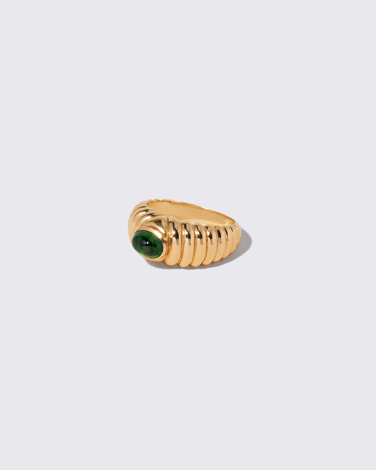 View from the side of the Vintage Ribbed Peridot Ring on light color background.