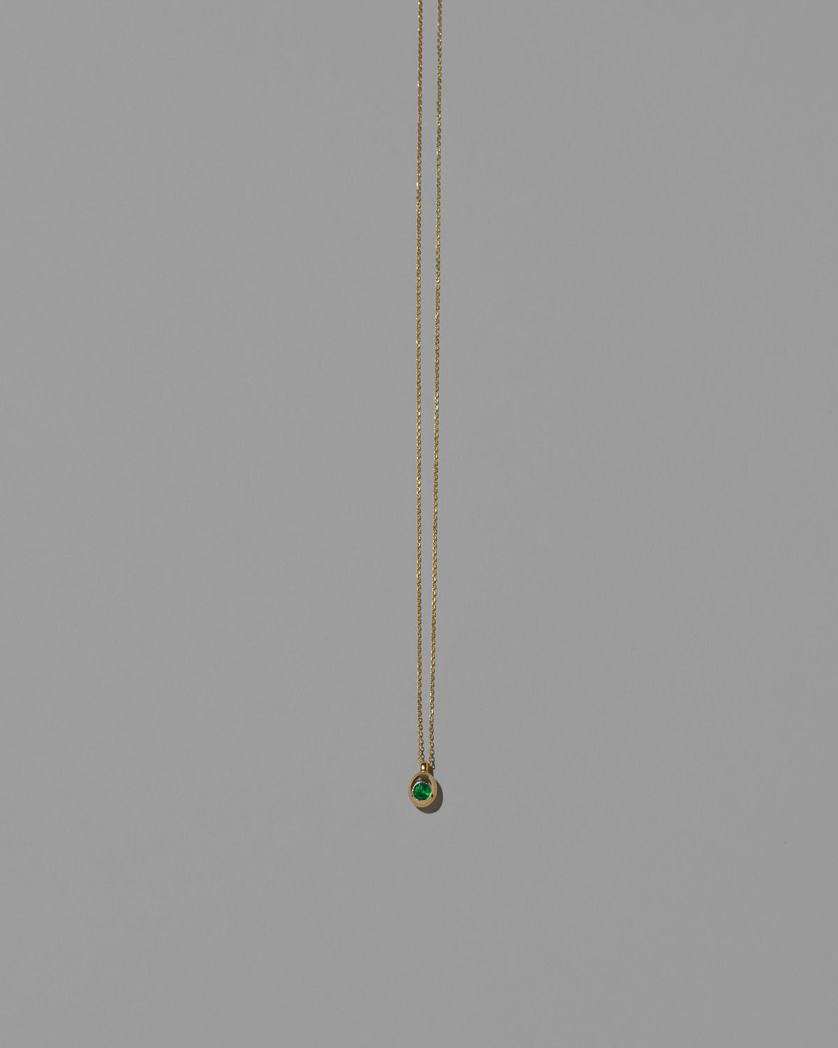 Emerald Birthstone Level Necklace on light color background.