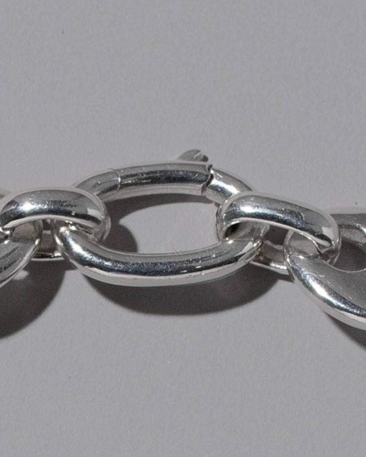 Closeup details of the CRZM Sterling Silver Oval Lobster Clasp on light color background.