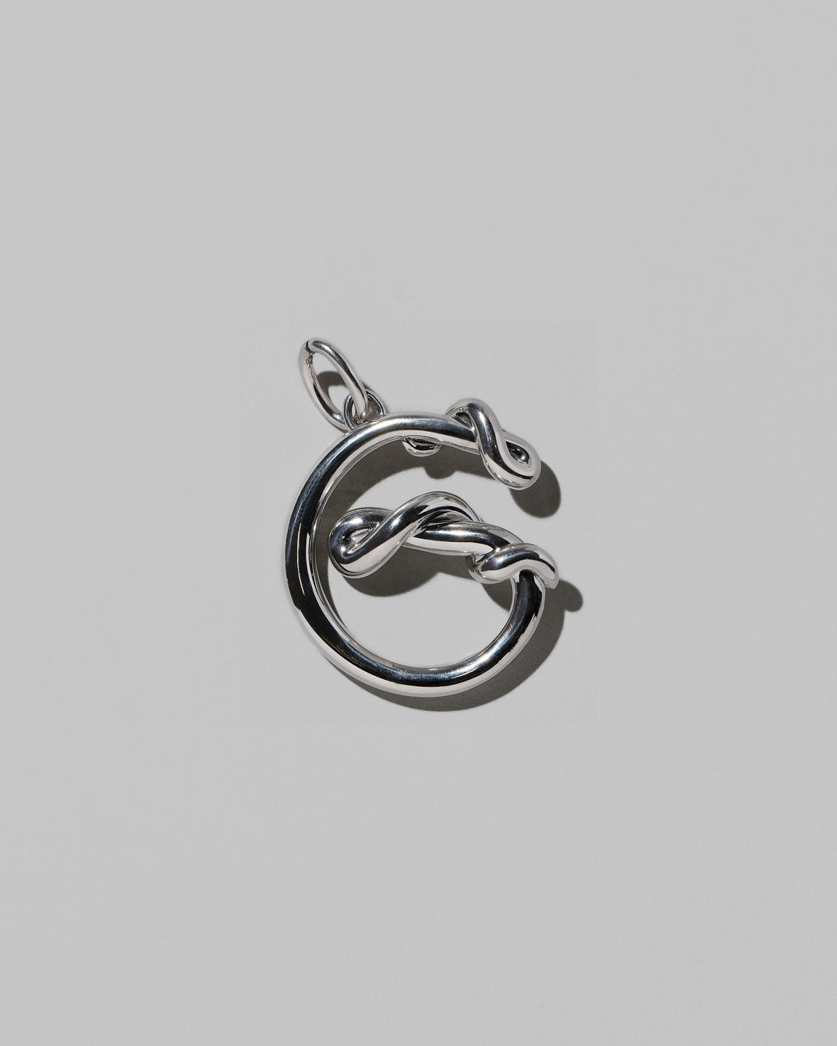 CRZM Sterling Silver Letter G Bag Charm on light color background.