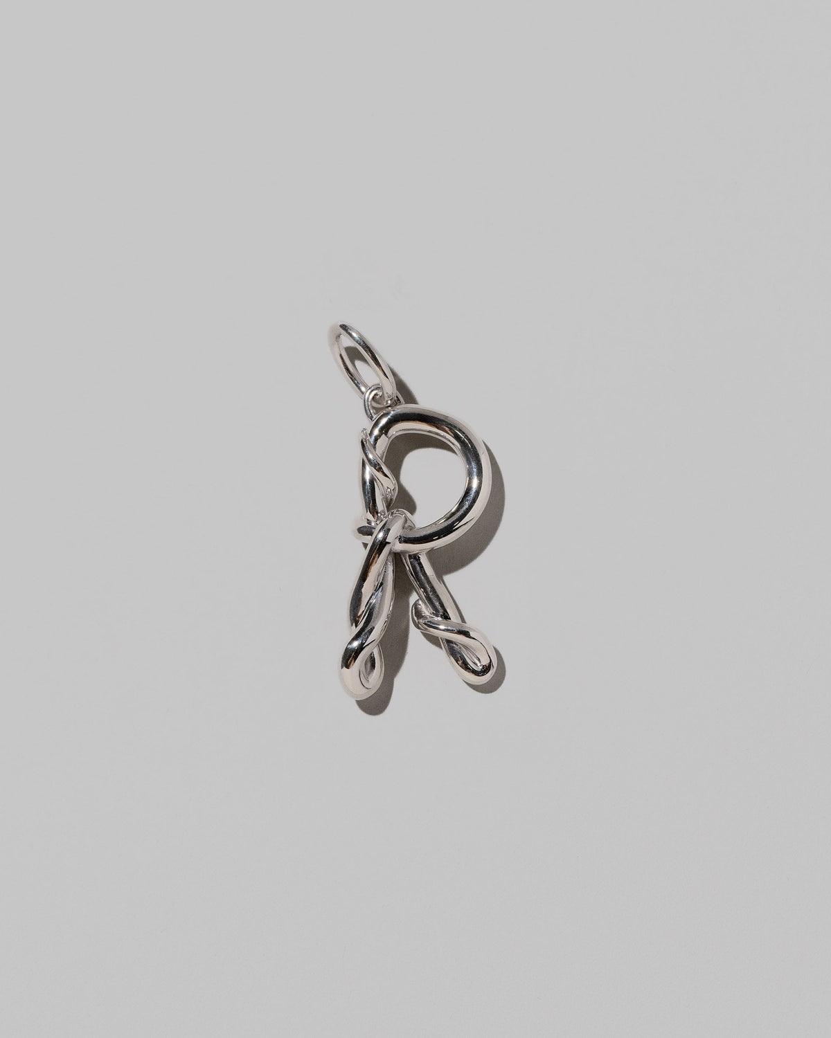 CRZM Sterling Silver Letter R Bag Charm on light color background.