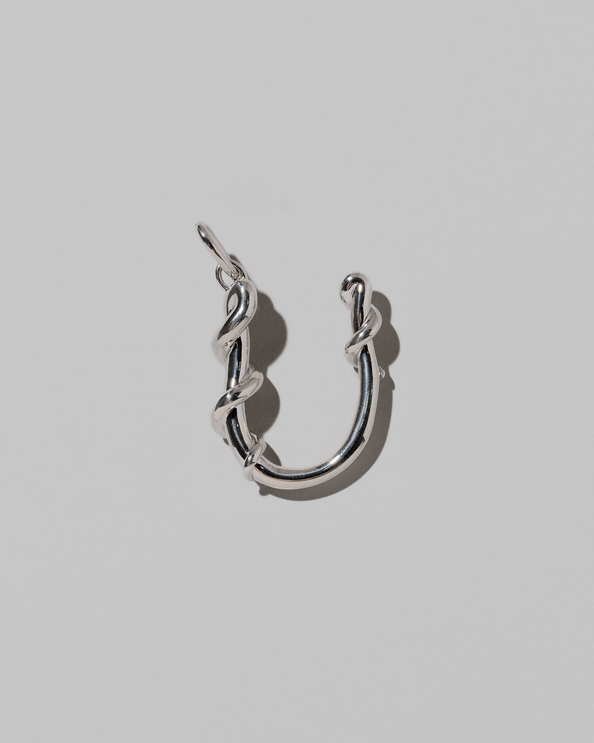 CRZM Sterling Silver Letter U Bag Charm on light color background.