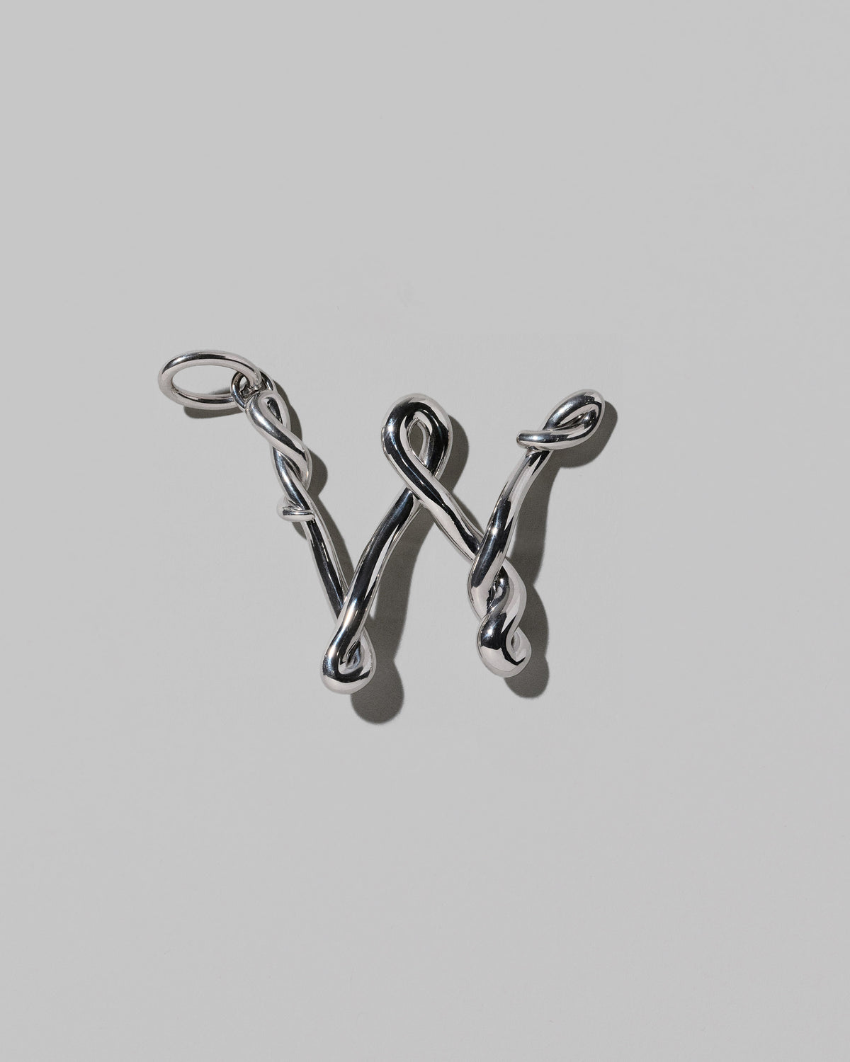 CRZM Sterling Silver Letter W Bag Charm on light color background.