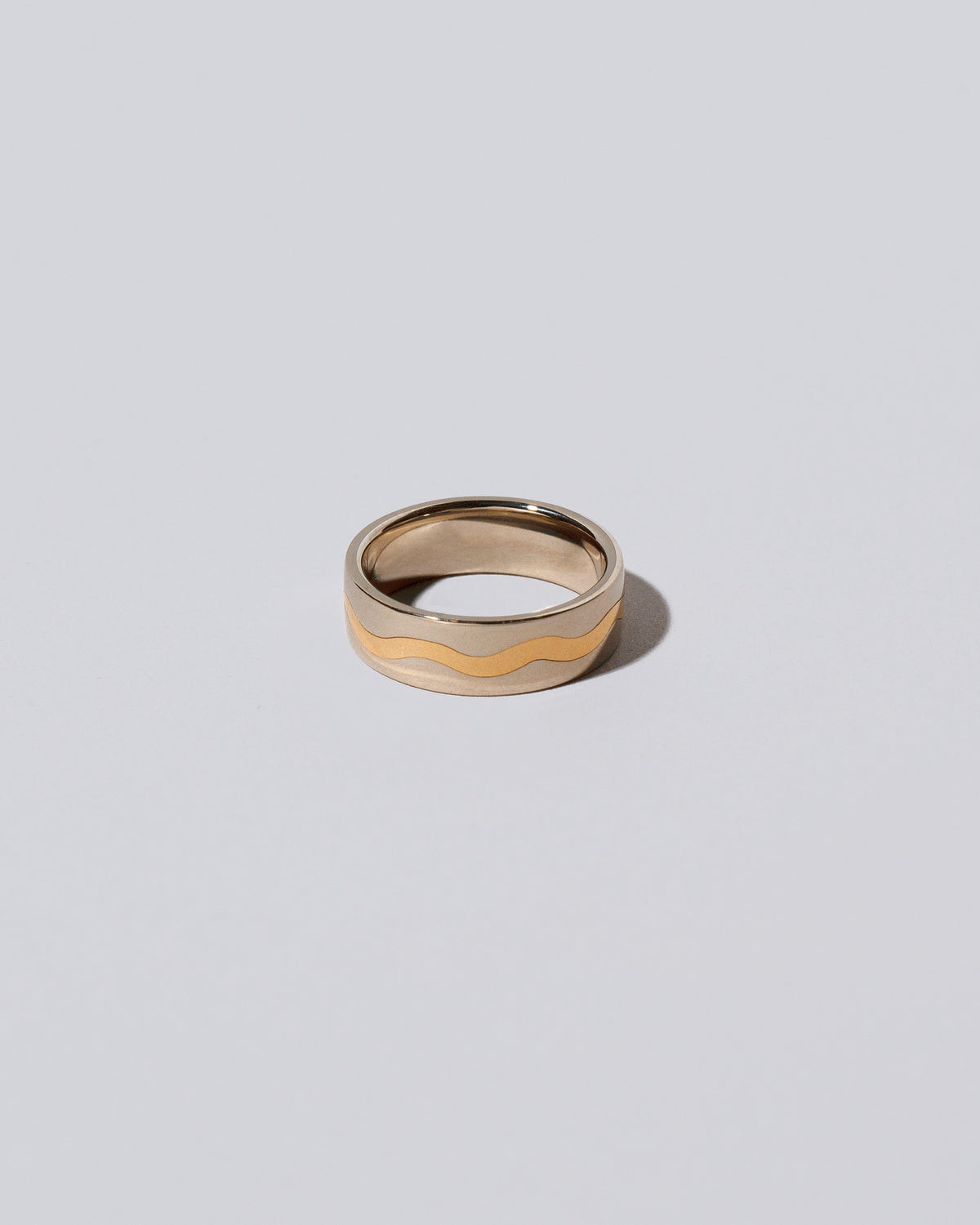 6mm Platinum Outside, Yellow 18K Inside Swimming Pool Band on light color background.