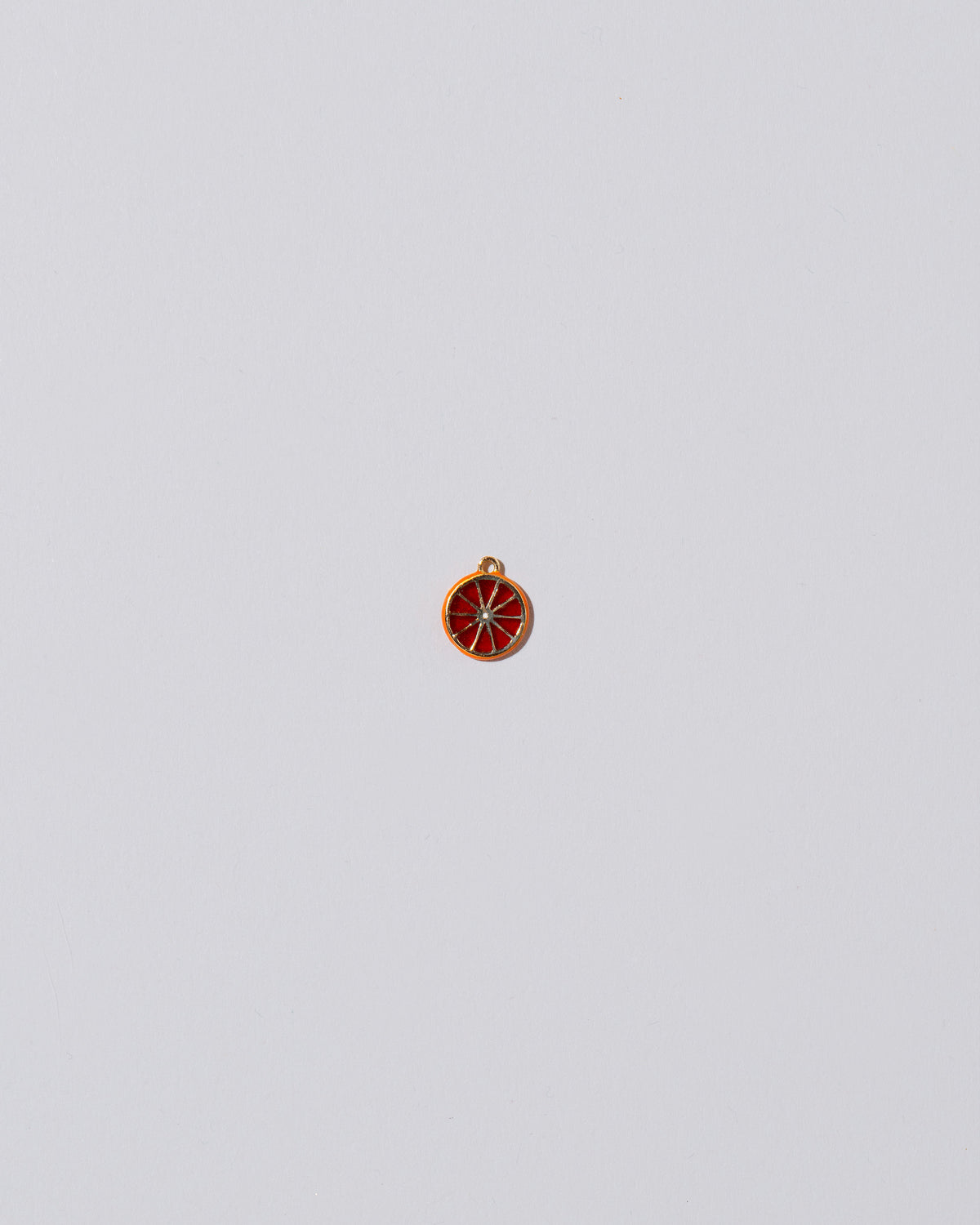 Small Tangerine Slice Charm on light color background.
