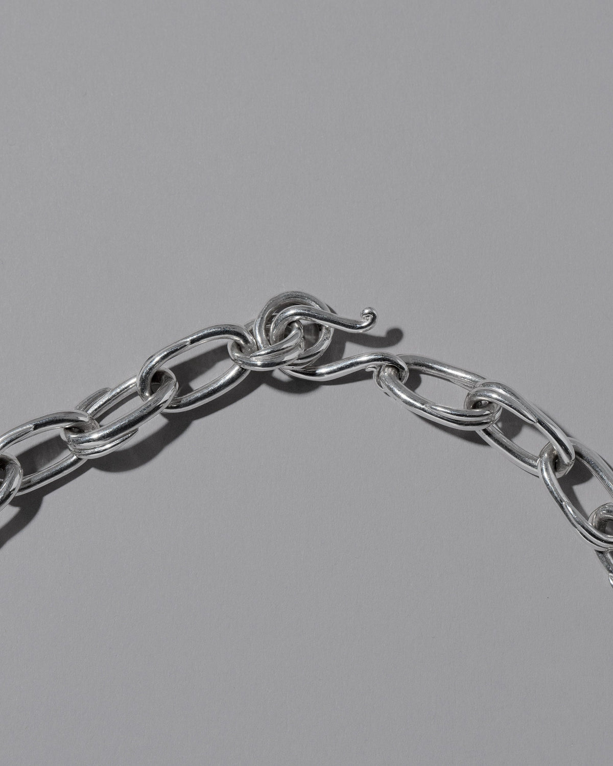 Closeup details of the CRZM Sterling Silver Canyon Necklace on light color background.