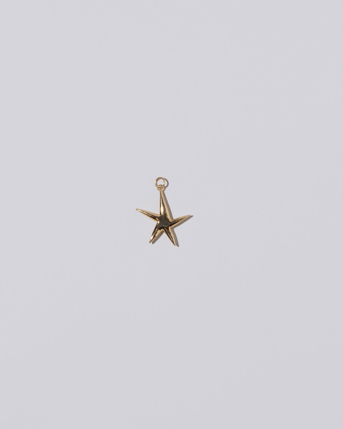 Verve Five Point Star Charm on light color background.