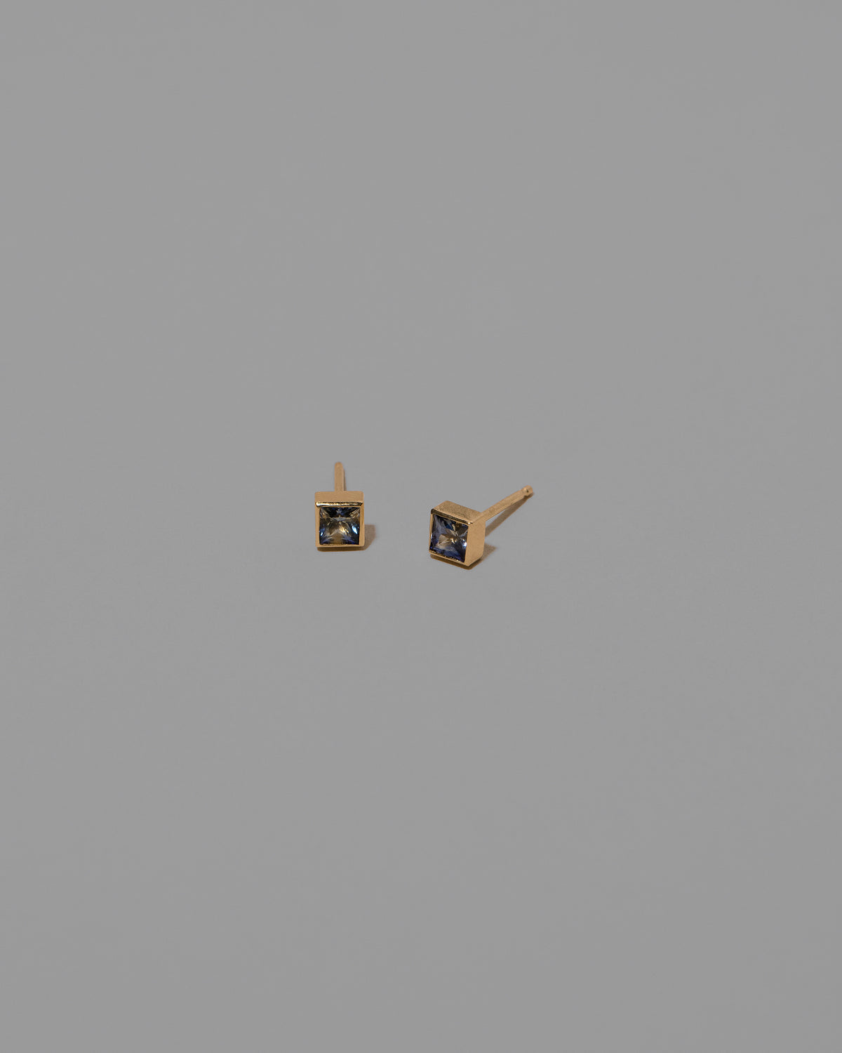 Petite Bicolor Blue Sapphire Square Frame Stud Earrings on light color background.