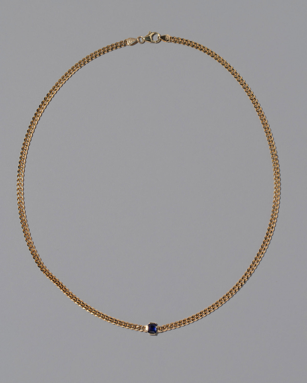 Blue Sapphire Fold Necklace on grey color background.
