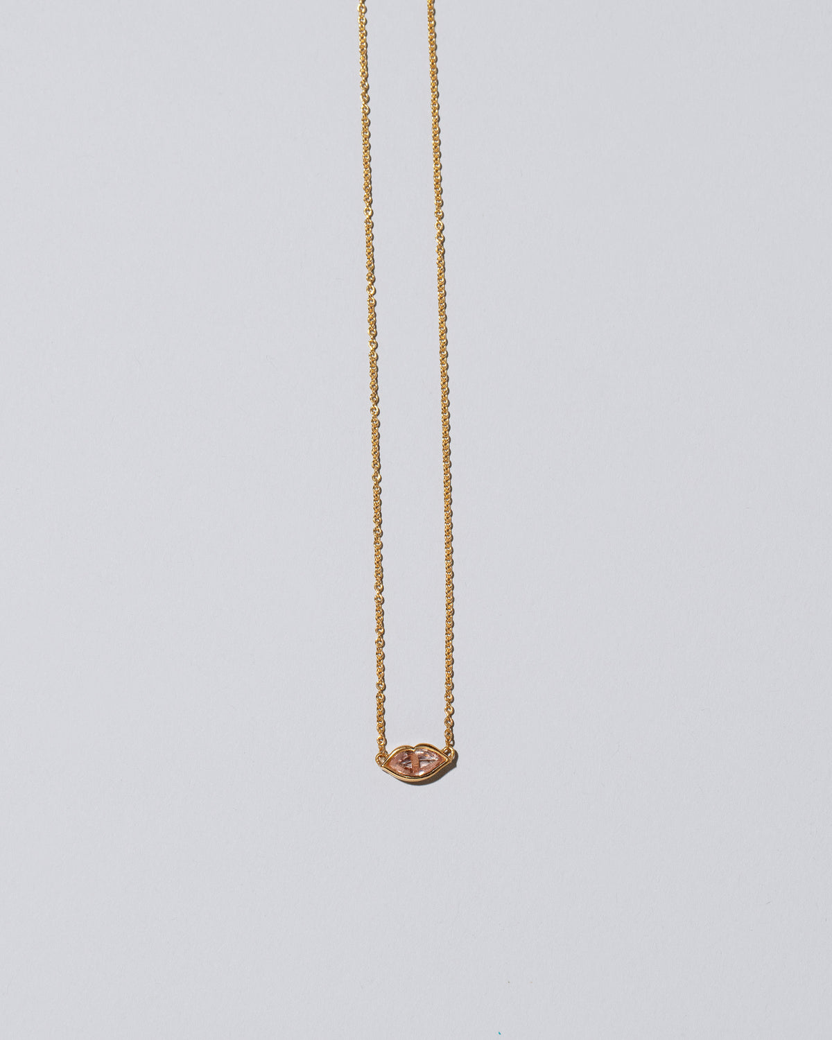 Light Pink Big Kiss Necklace on light color background.