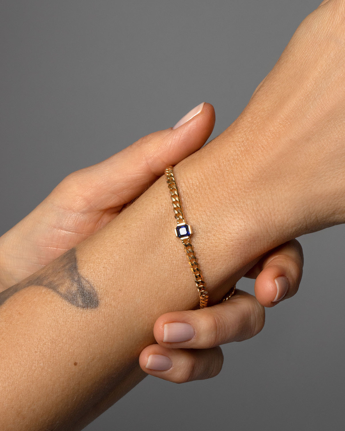 Gold Blue Sapphire Fold Bracelet on model.
