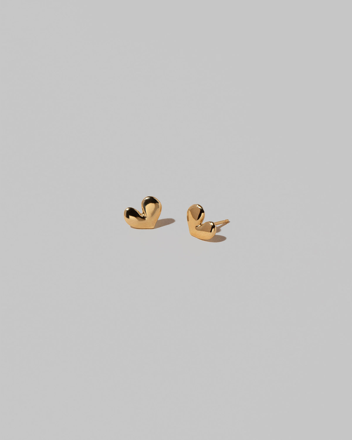 Shape Three Small Thousand & One Night Heart Stud Earrings on light color background.