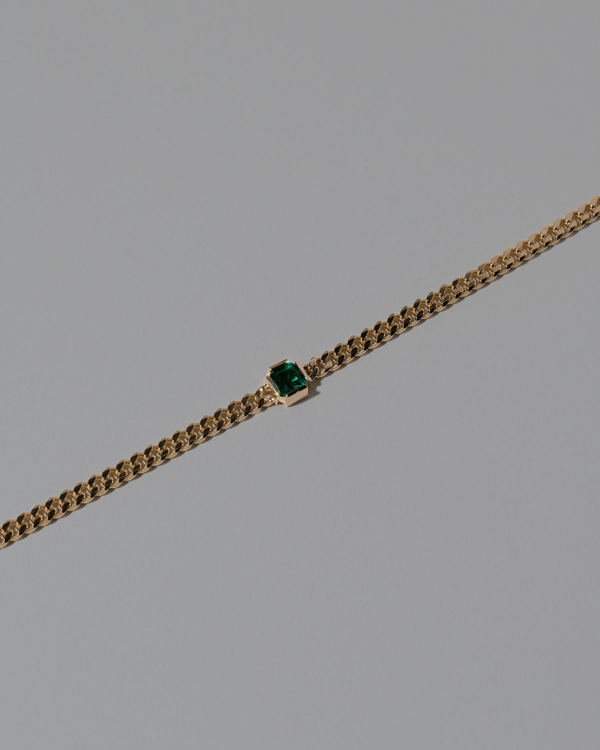 Closeup details of the Gold Emerald Fold Bracelet on light color background.
