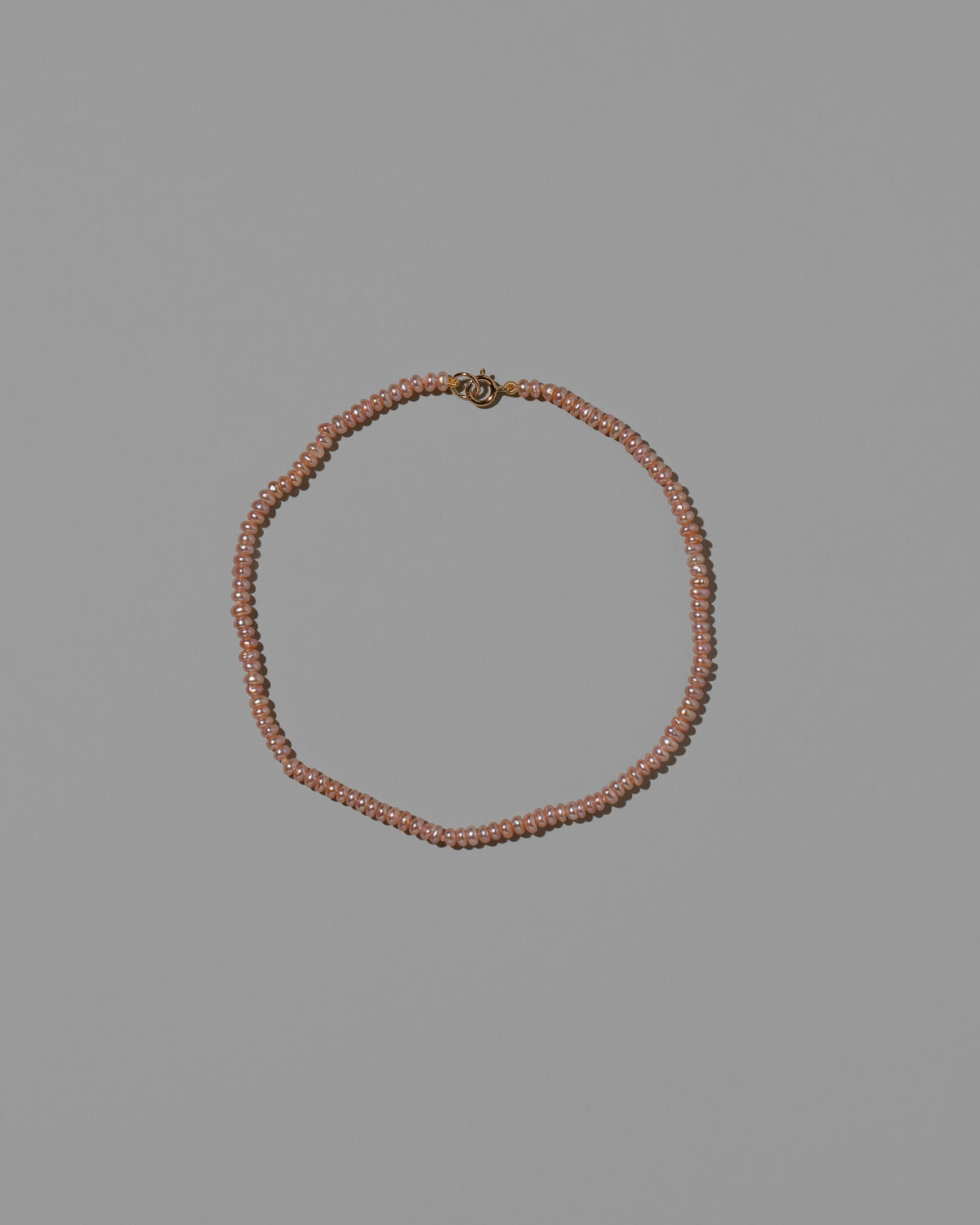 Pink Seed Pearl Anklet on light color background.