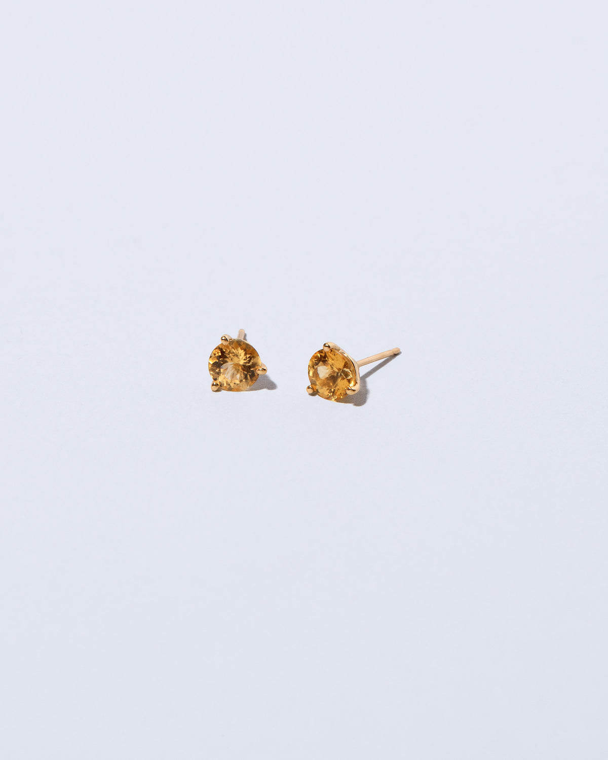 Super Yellow Beryl Martini Stud Earrings on light color background.