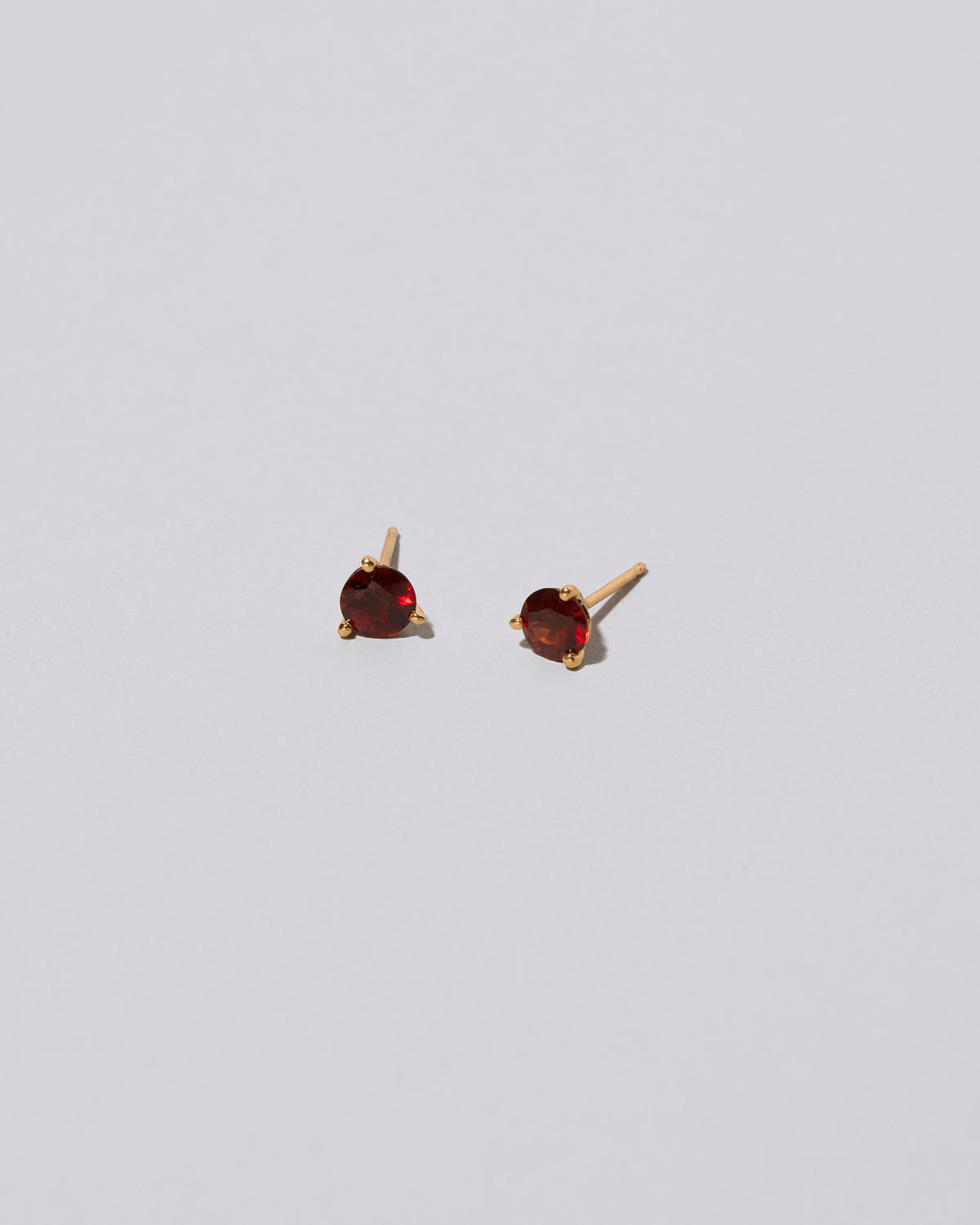 Mega Red Garnet Martini Stud Earrings on light color background.
