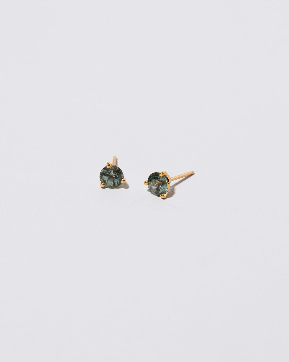 Mega Teal Sapphire Martini Stud Earrings on light color background.