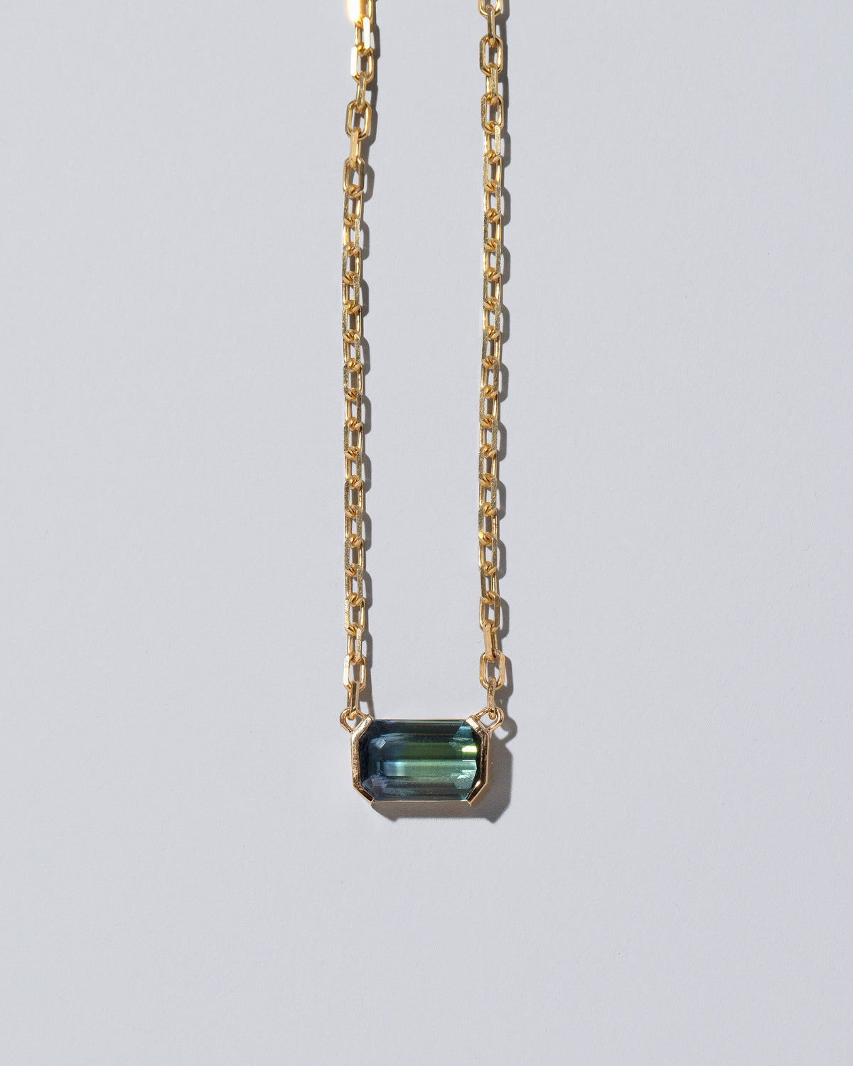 Closeup details of the Attunement Necklace on light color background.