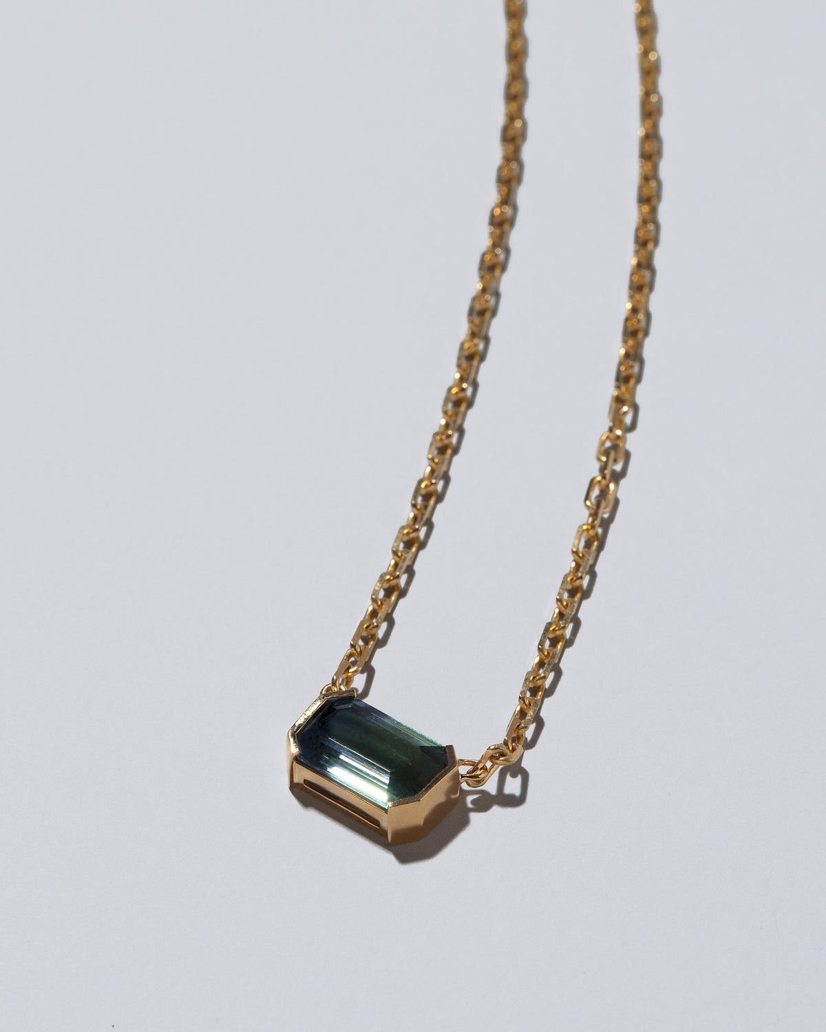 Closeup details of the Attunement Necklace on light color background.
