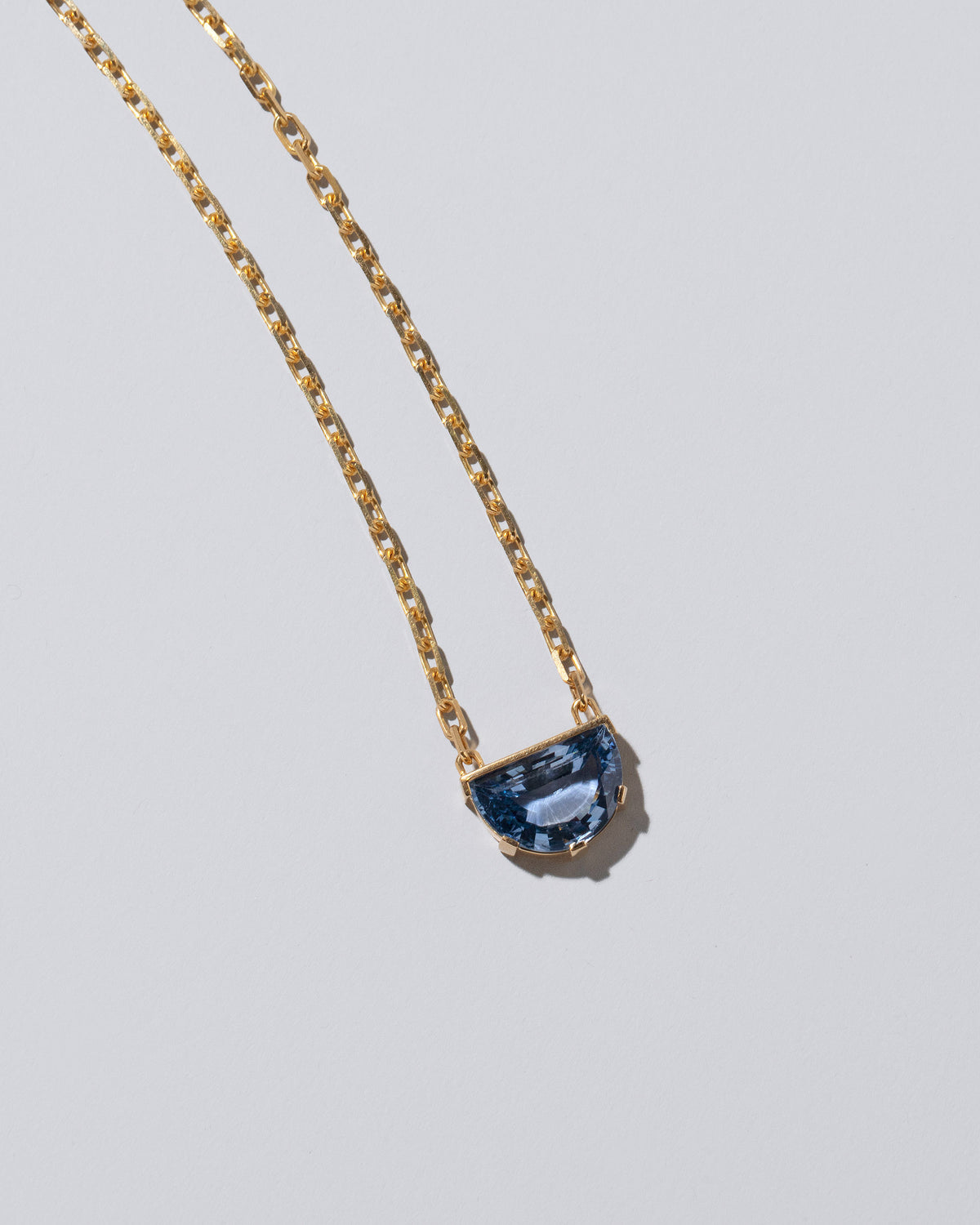 Closeup details of the Reverence Necklace on light color background.