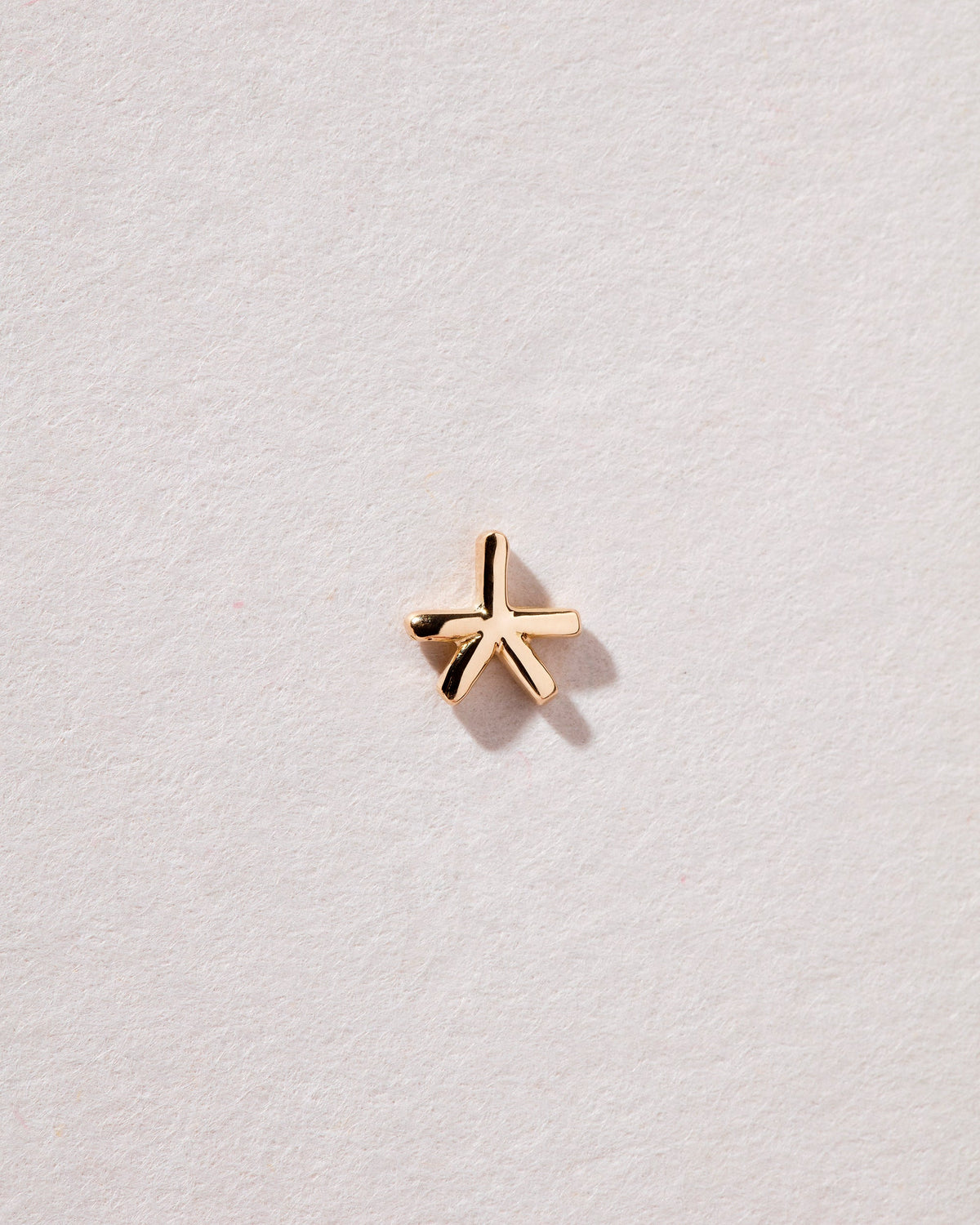 Star Stud Earring Single on light color background.