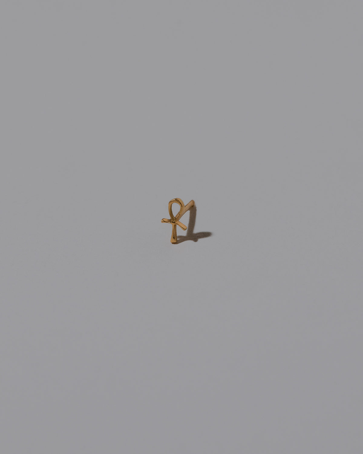 Ankh Stud Earring Single on light color background.