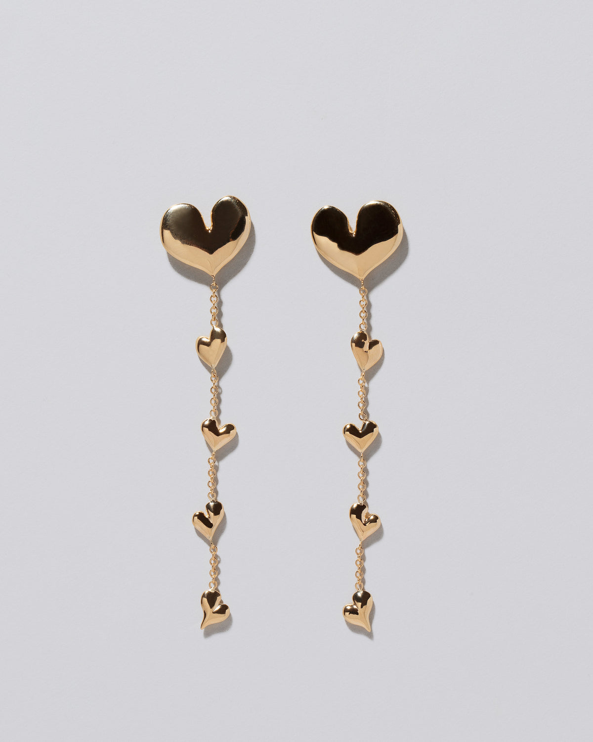 Gold Thousand & One Night Heart Shoulder Duster Earrings on light color background.