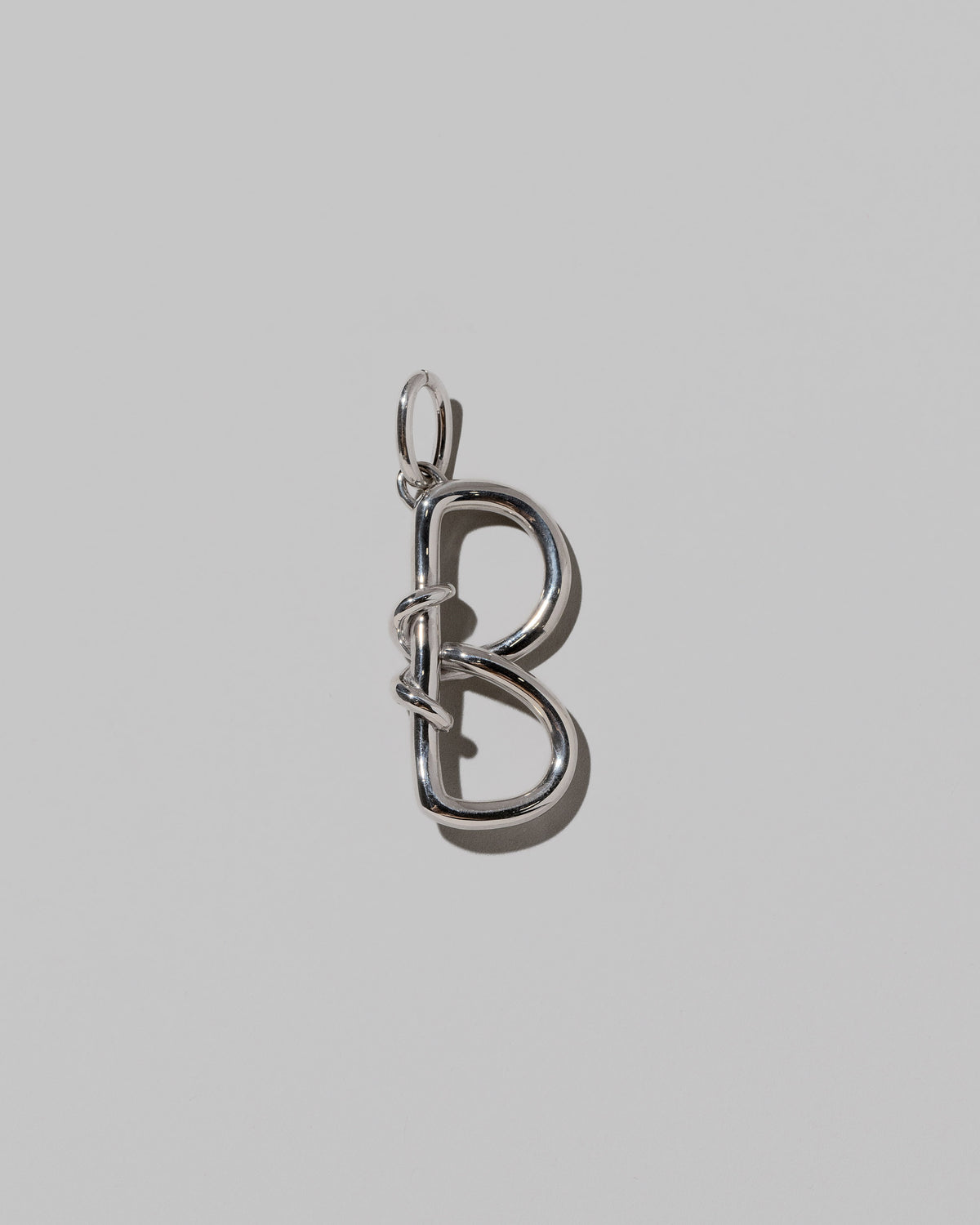 CRZM Large Letter B Charm set in sterling silver on light color background.