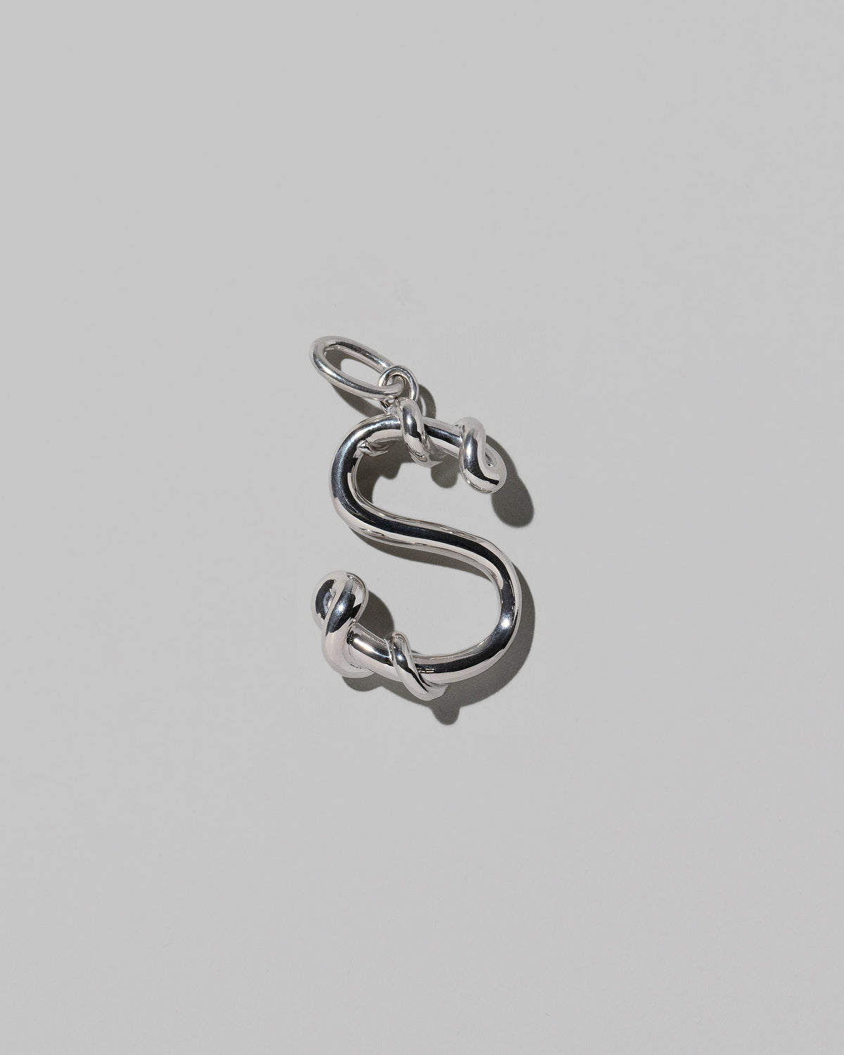 CRZM Large Letter S Charm set in sterling silver on light color background.