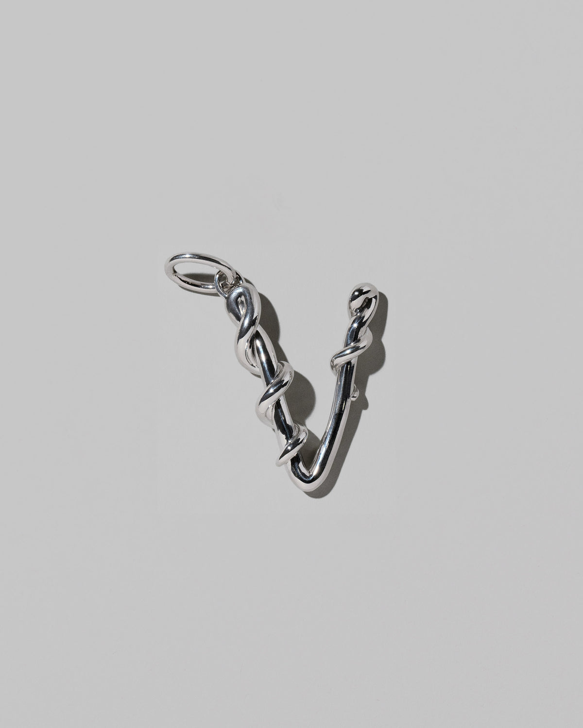 CRZM Large Letter V Charm set in sterling silver on light color background.