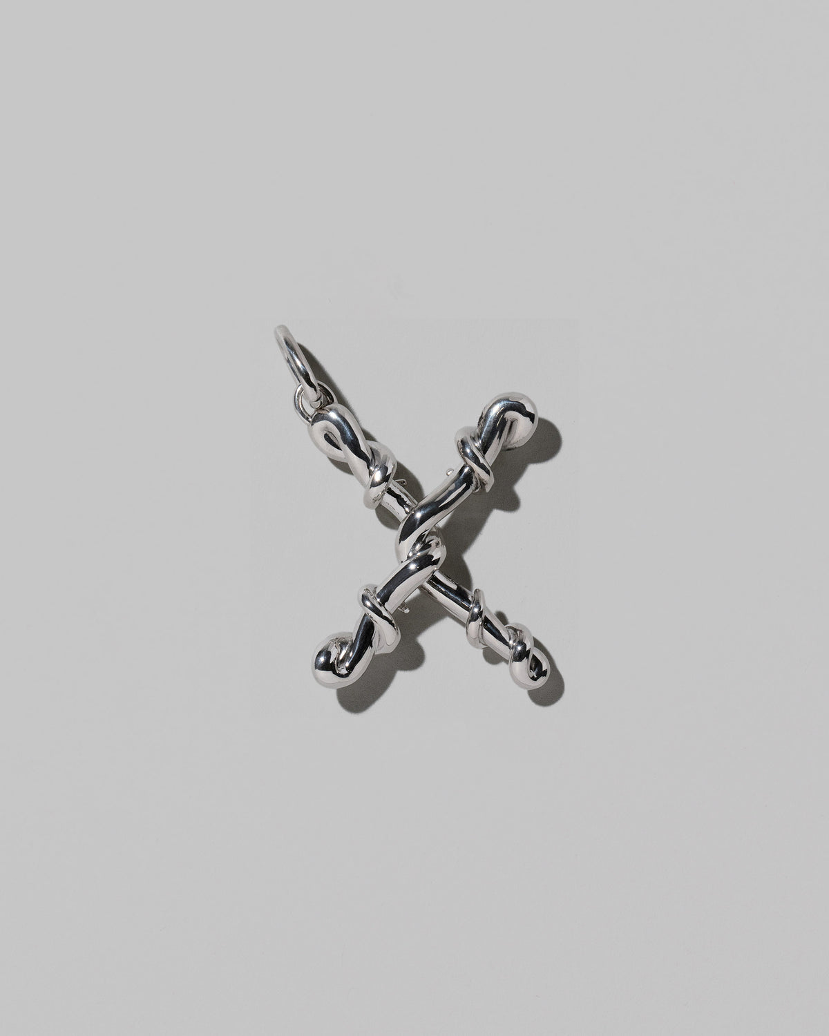 CRZM Large Letter X Charm set in sterling silver on light color background.