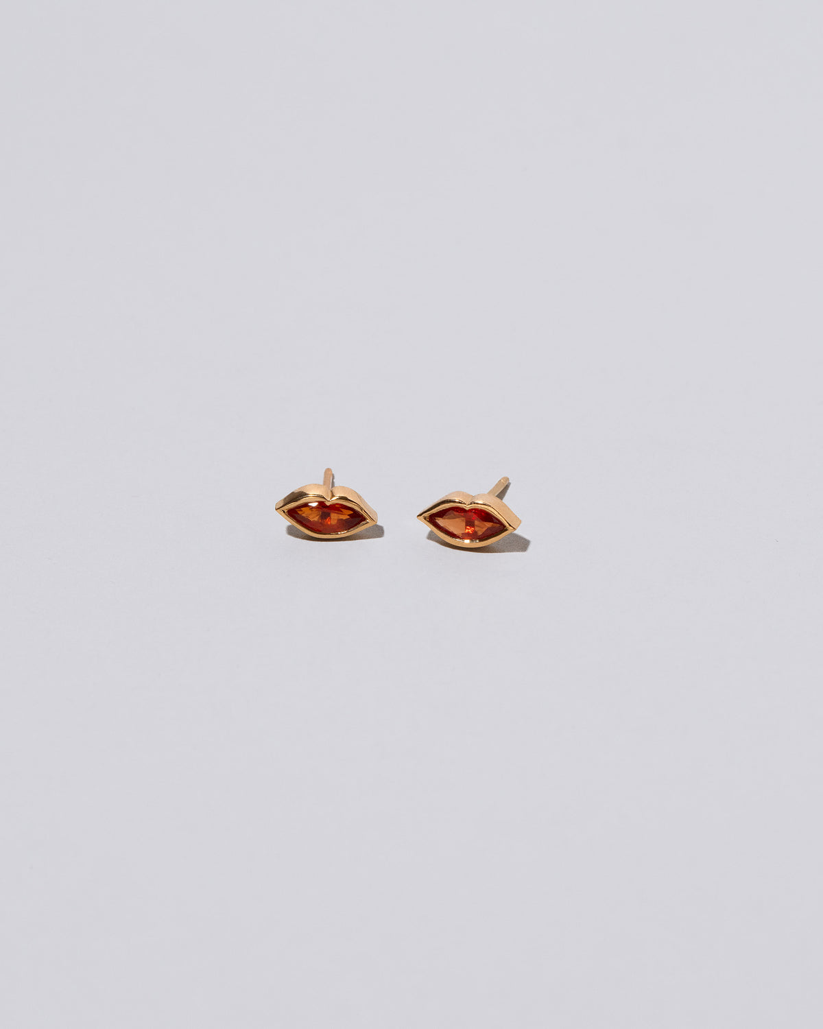 Red Big Kiss Stud Earrings on light color background.