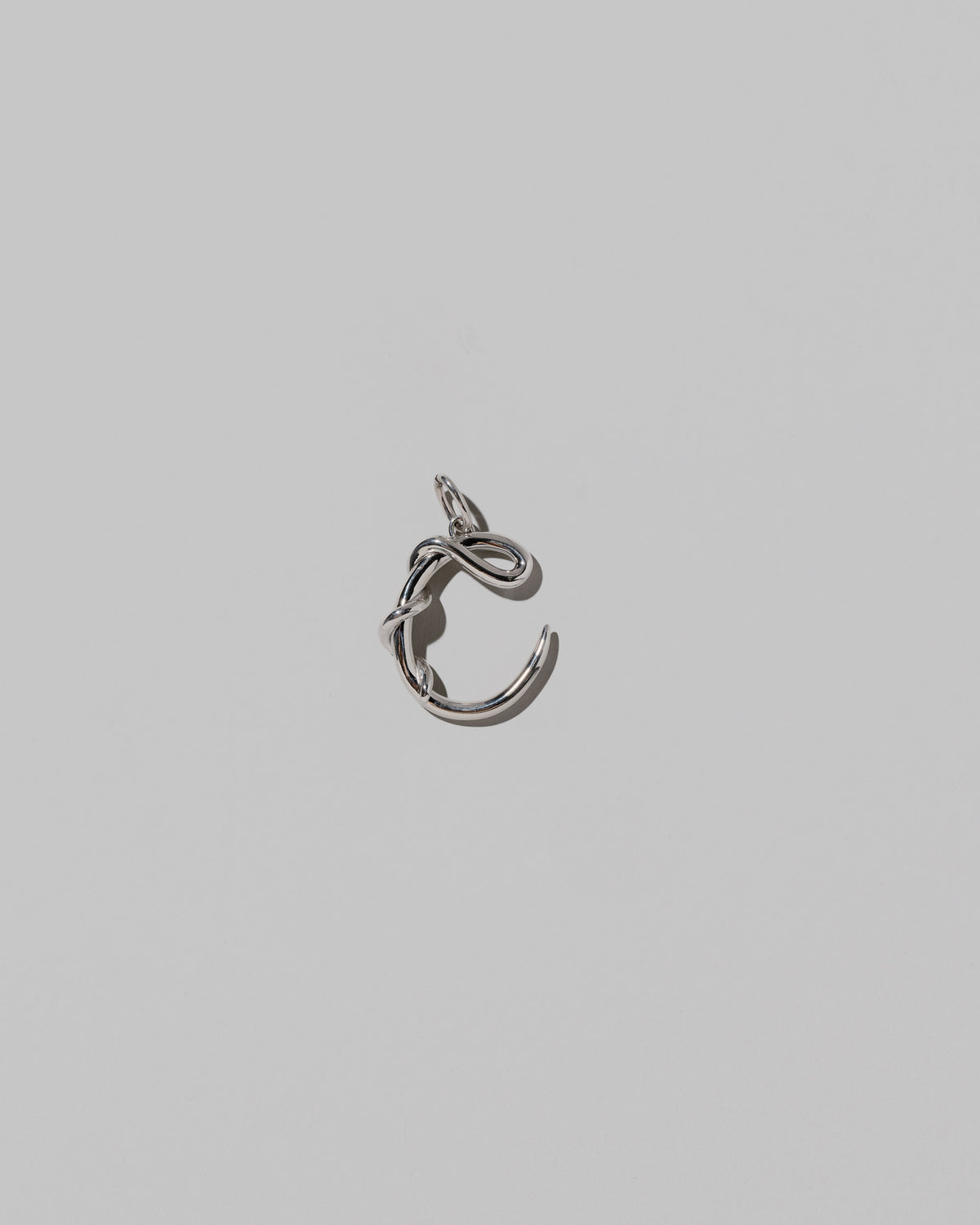 CRZM Medium Letter C Charm set in sterling silver on light color background.