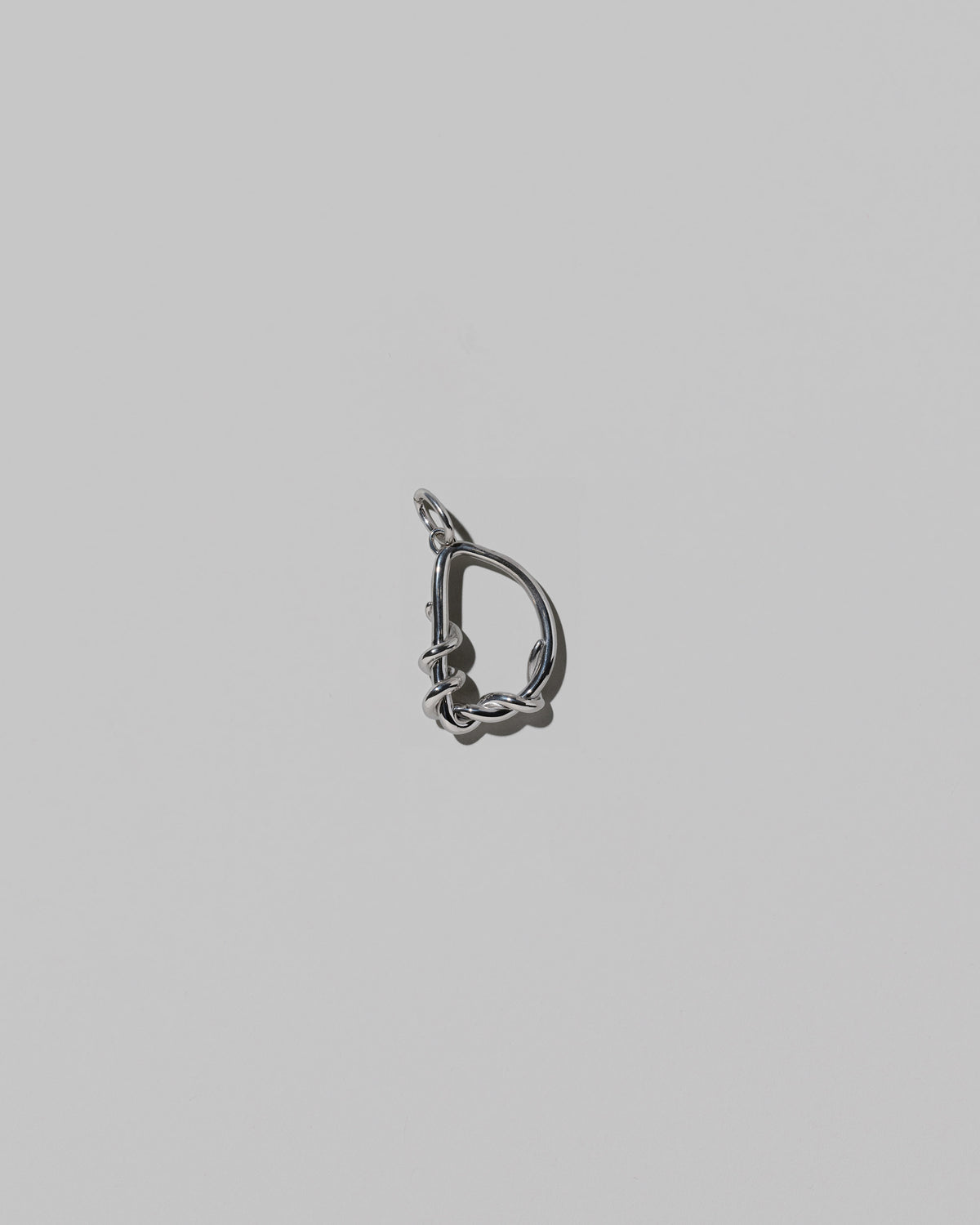 CRZM Medium Letter D Charm set in sterling silver on light color background.