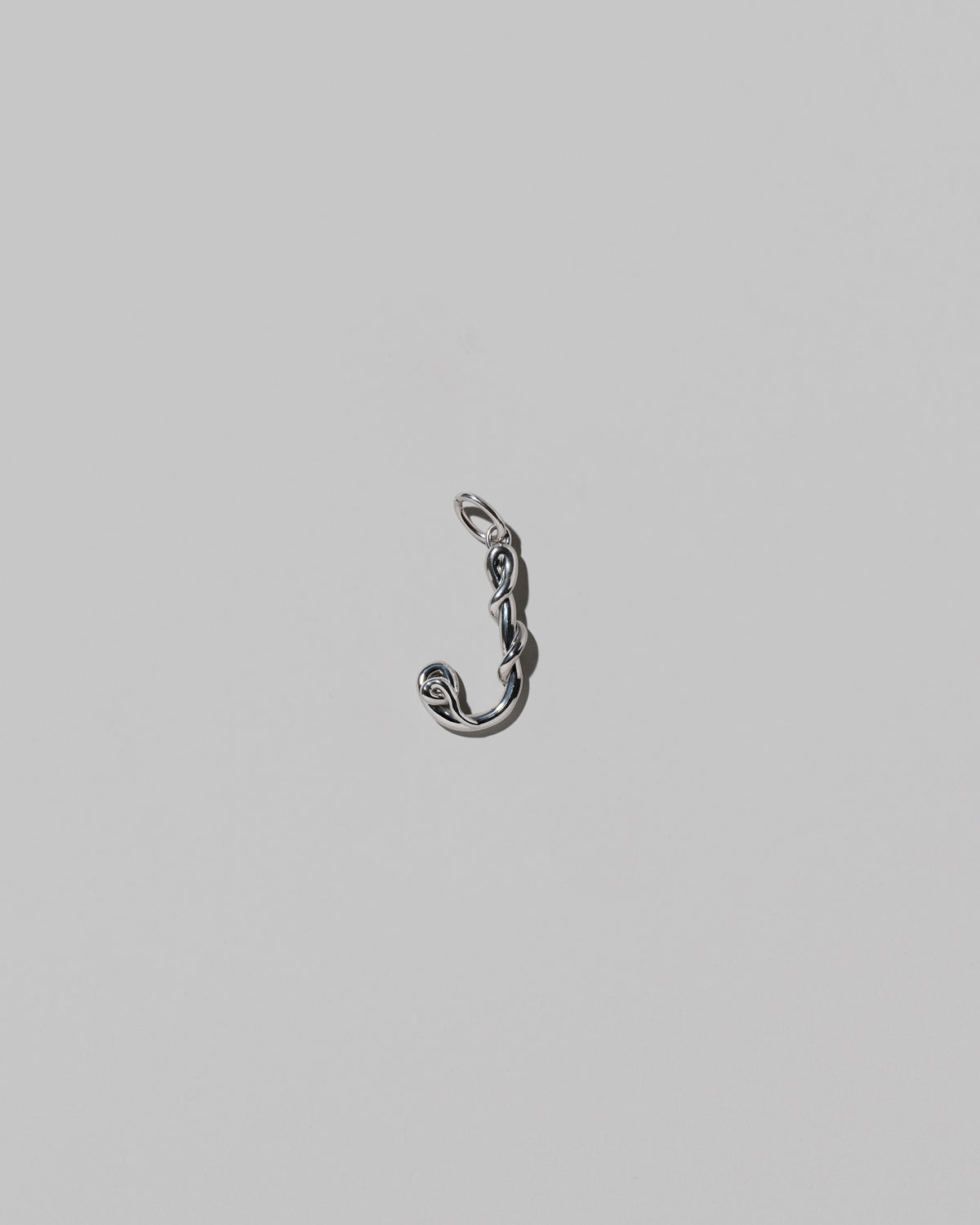 CRZM Medium Letter J Charm set in sterling silver on light color background.