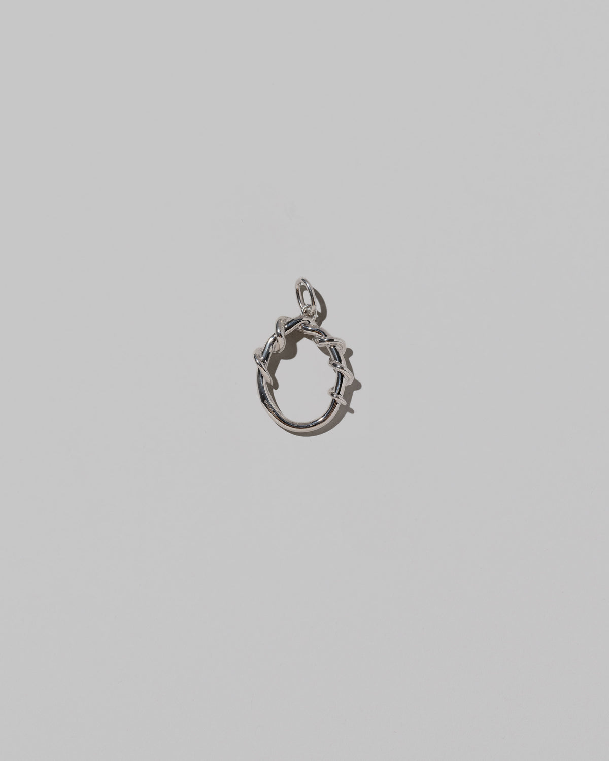 CRZM Medium Letter O Charm set in sterling silver on light color background.