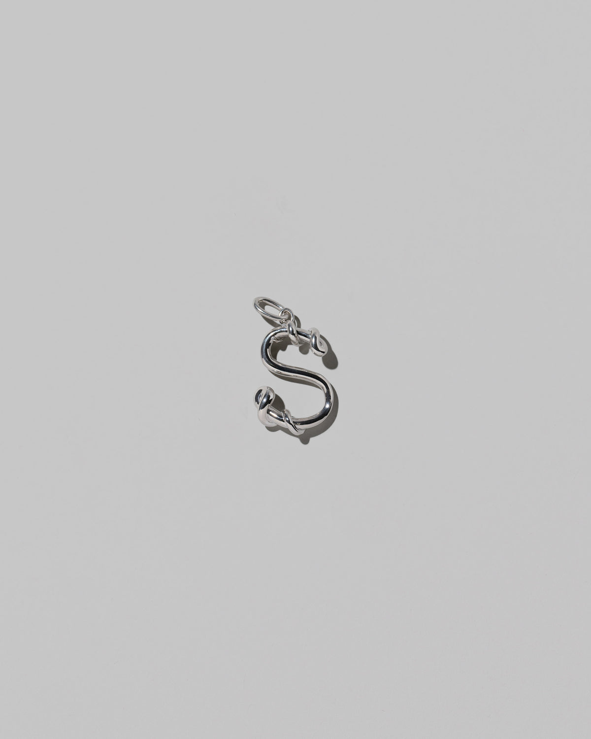CRZM Medium Letter S Charm set in sterling silver on light color background.