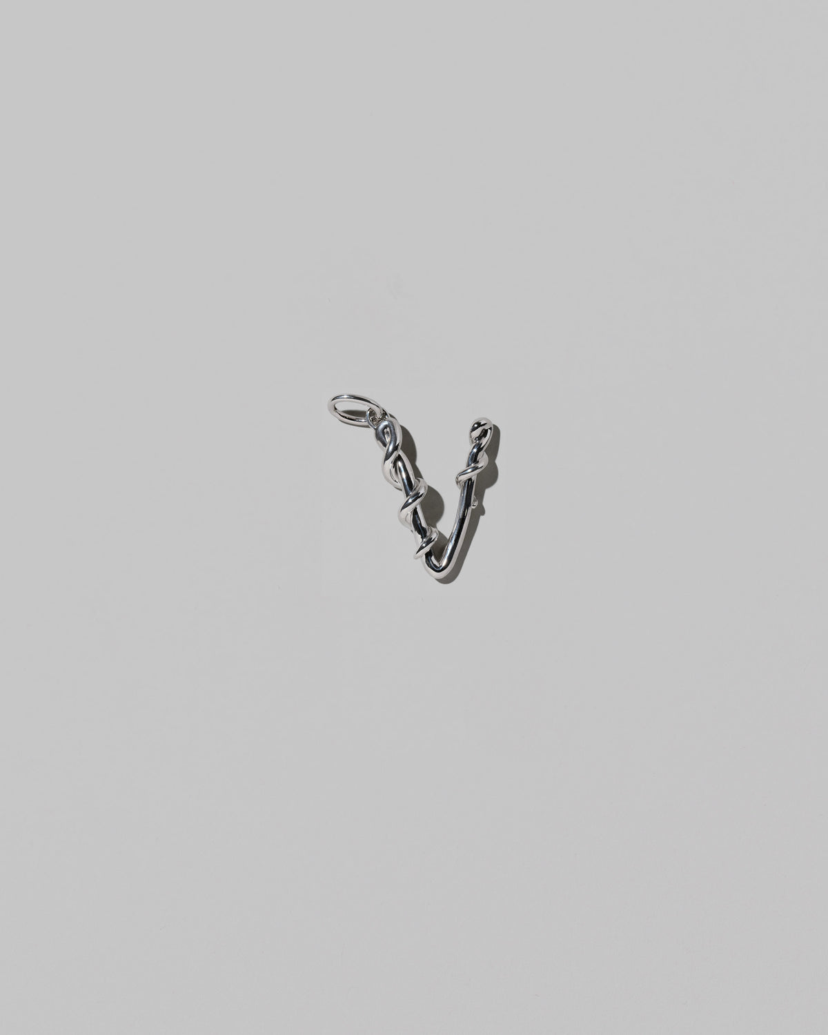 CRZM Medium Letter V Charm set in sterling silver on light color background.