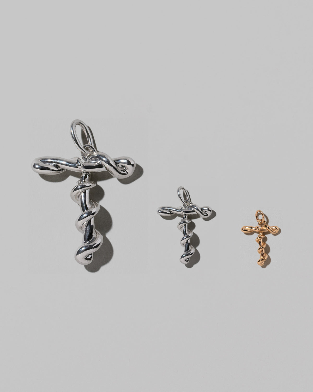 CRZM Large Sterling Silver, Medium Sterling Silver & Mini Letter T Charms set in solid gold on light color background.