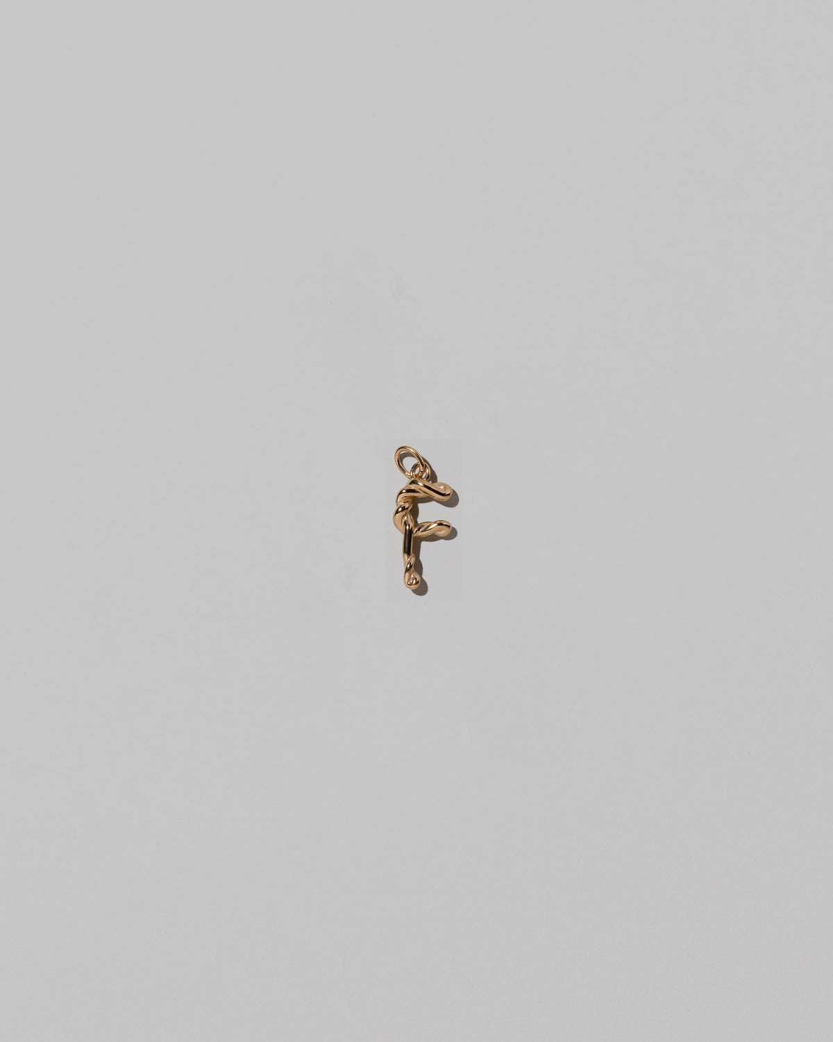 CRZM Mini Letter F set in solid gold on light color background.