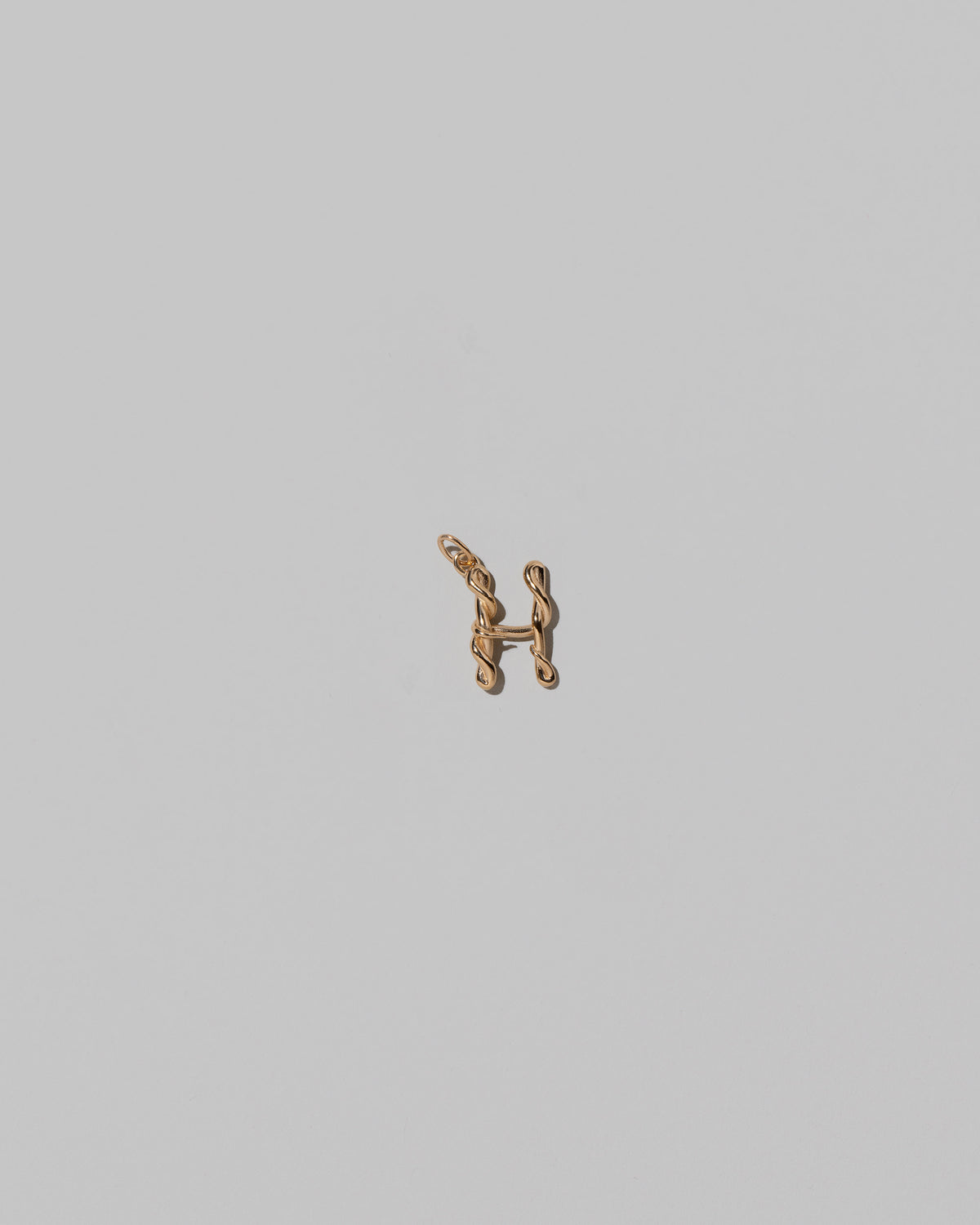 CRZM Mini Letter H set in solid gold on light color background.