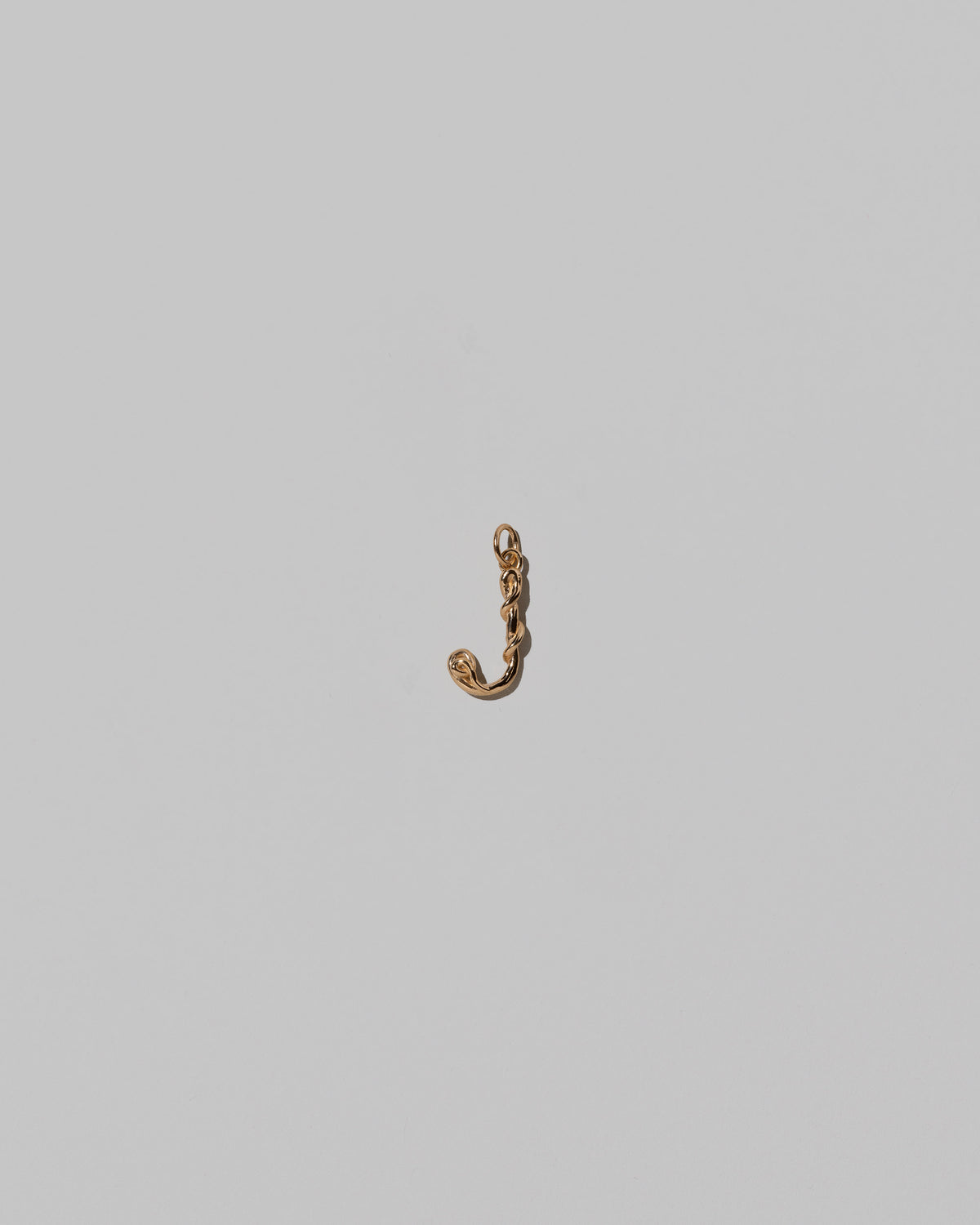CRZM Mini Letter J set in solid gold on light color background.