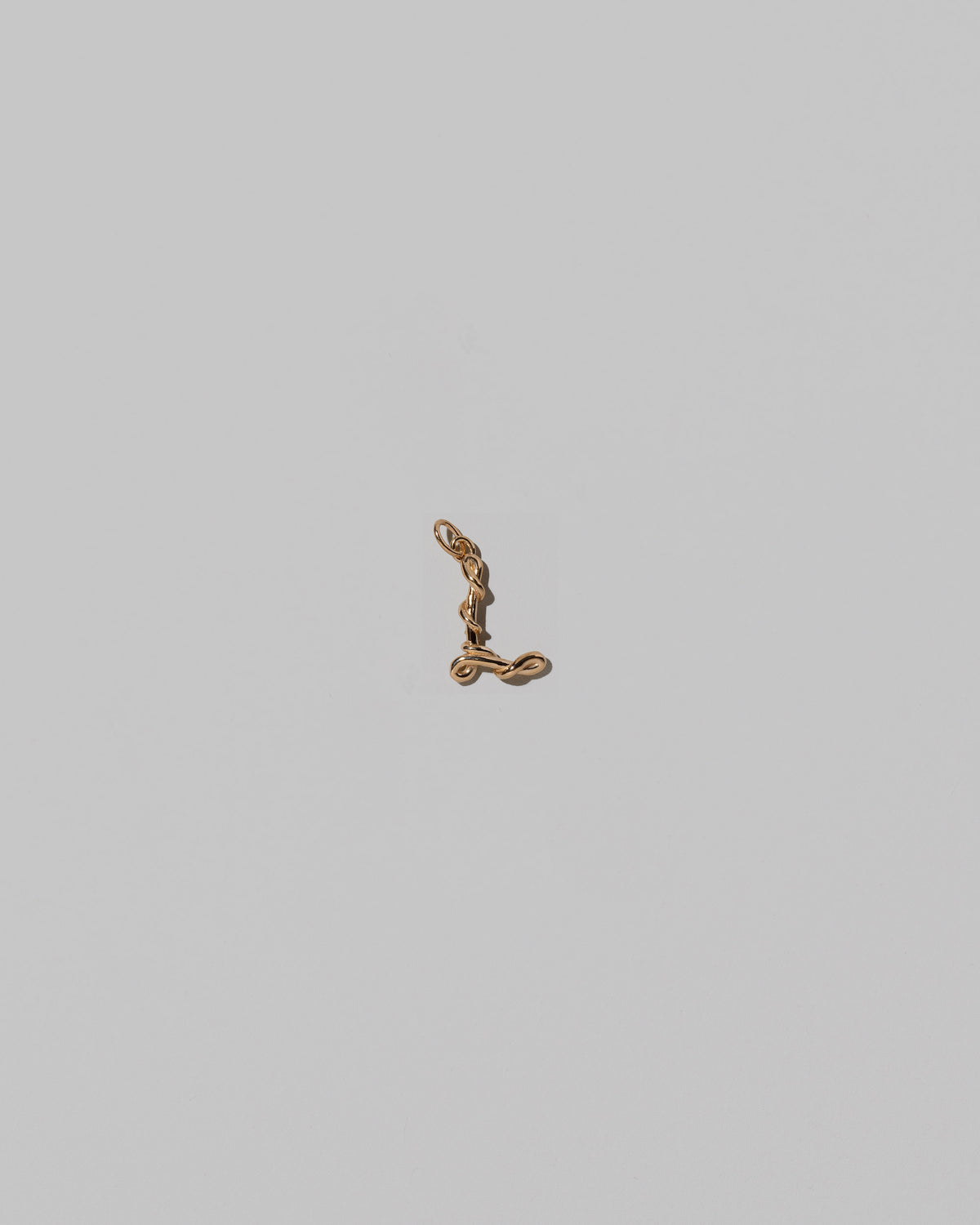 CRZM Mini Letter L set in solid gold on light color background.